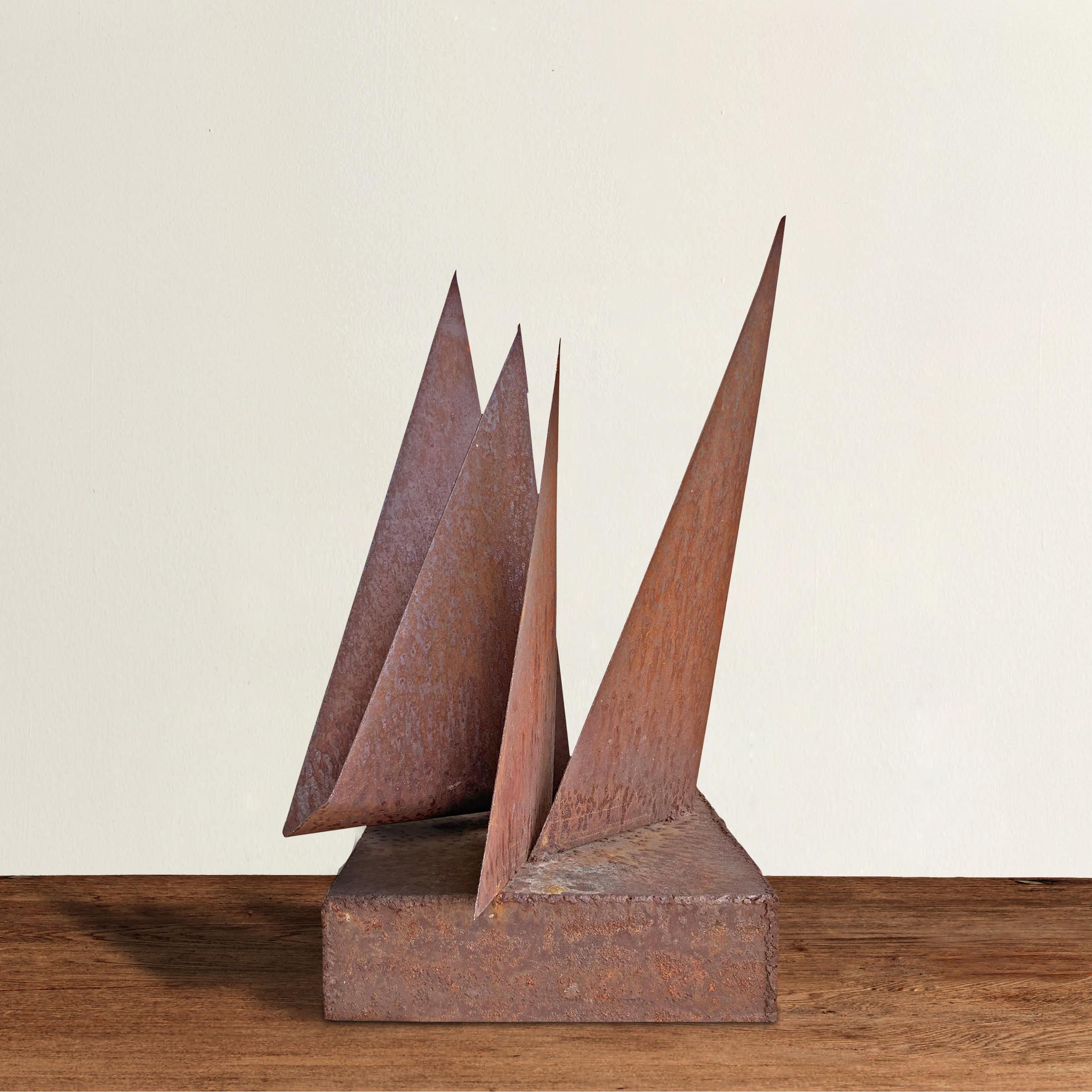 A striking mid-20th century Brutalist iron sculpture constructed with four large triangle shapes reminiscent of sail boats in a harbor, welded to a rectangular base and with a wonderful raw texture and fabulous rust finish.