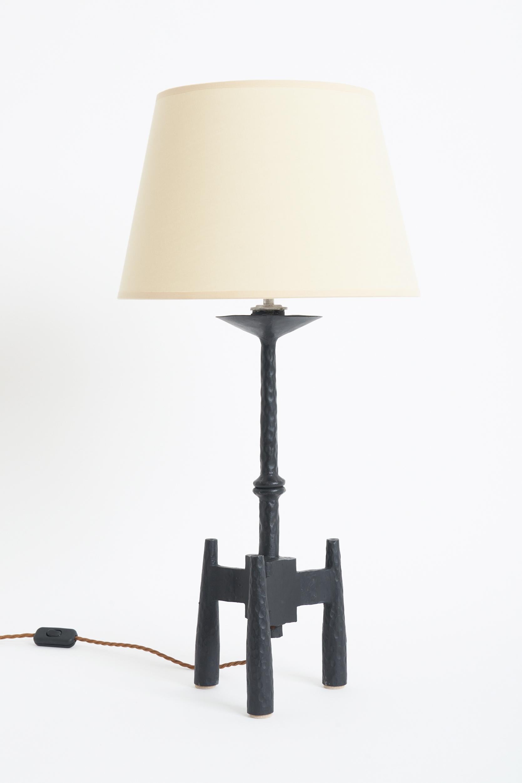 A Brutalist wrought iron table lamp 
Spanish, mid 20th Century 
With the shade: 71 cm high by 35.5 cm diameter 
Lamp base only: 53 cm high by 19 cm diameter