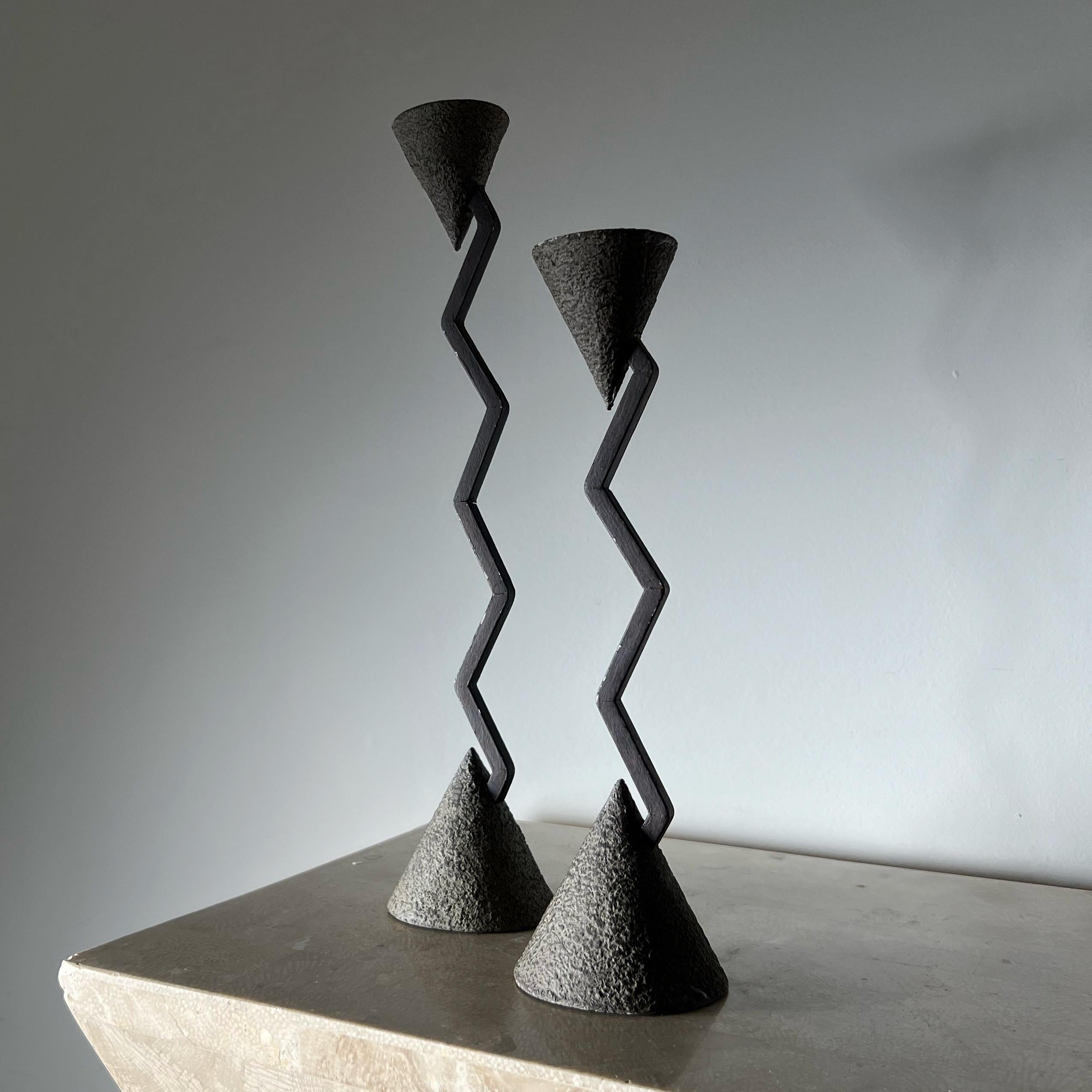 A pair of brutalist hand-forged iron candlesticks by Milano Series. Made in the Philippines circa 1990. Fabulous geometry with conical bases and tops and shameless zigzag bodies. Black velvet vases also include original provenance stickers. Minor