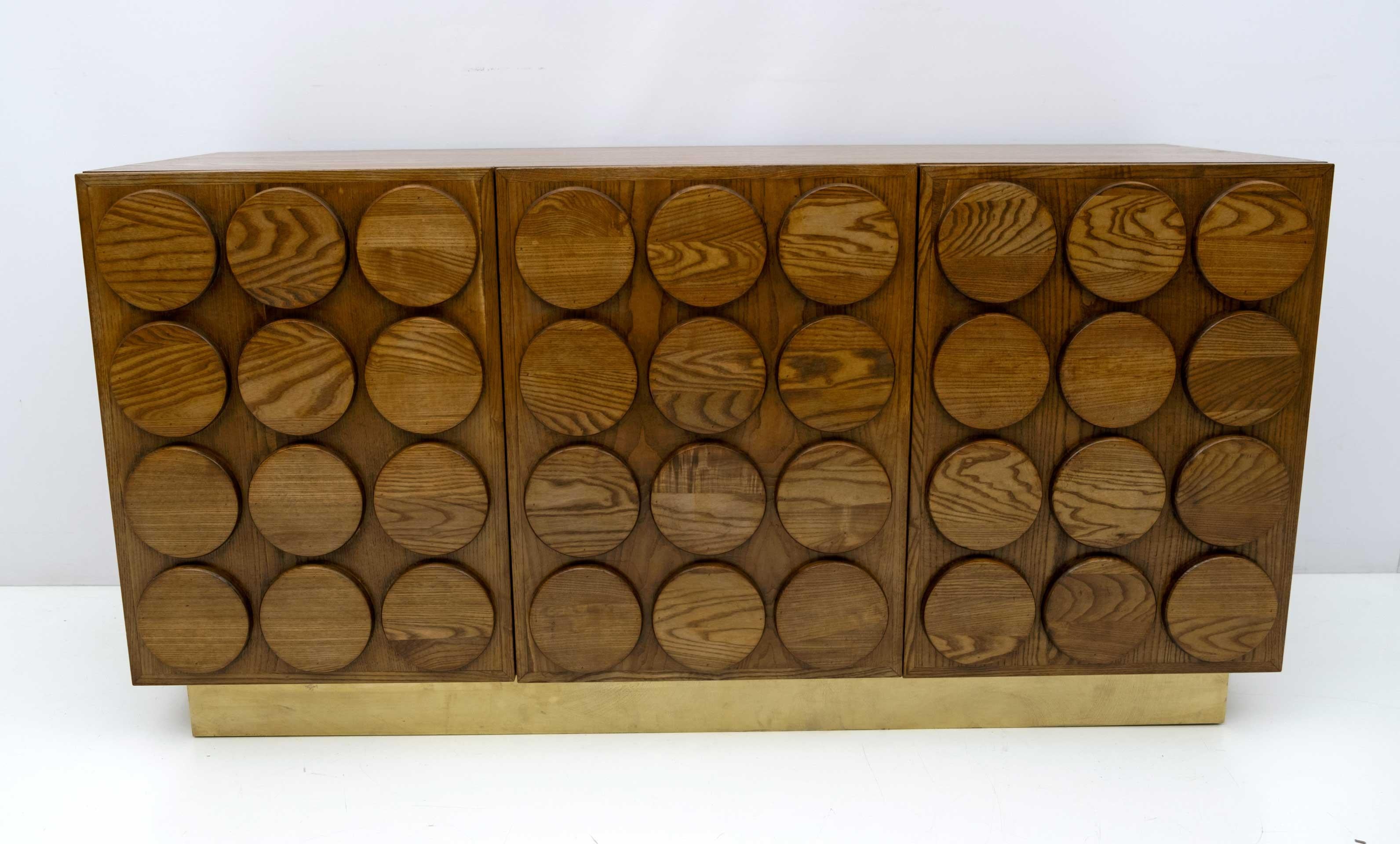 Meuble de bar à trois portes de style brutaliste en bois de châtaignier. Avec des lignes géométriques et harmonieuses, le meuble est également embelli par la bande de laiton sous-jacente.
