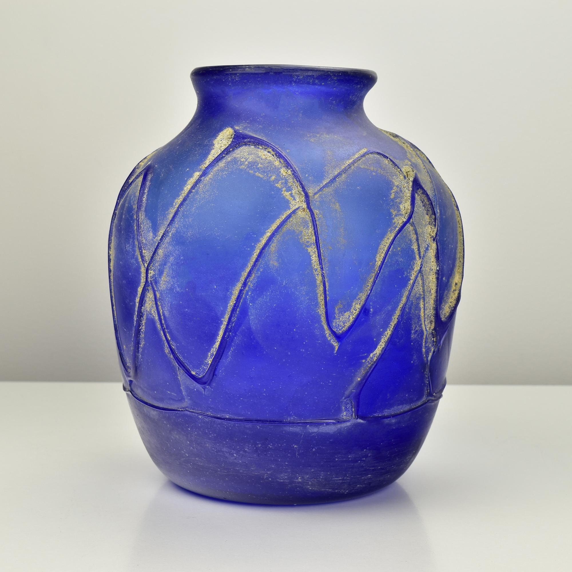 This vintage Murano Scavo vase in cobalt blue captures the essence of Italian glass artistry. The Scavo technique gives it a weathered, ancient look, reminiscent of artifacts from antiquity. The vase features a rich blue hue with a textured,