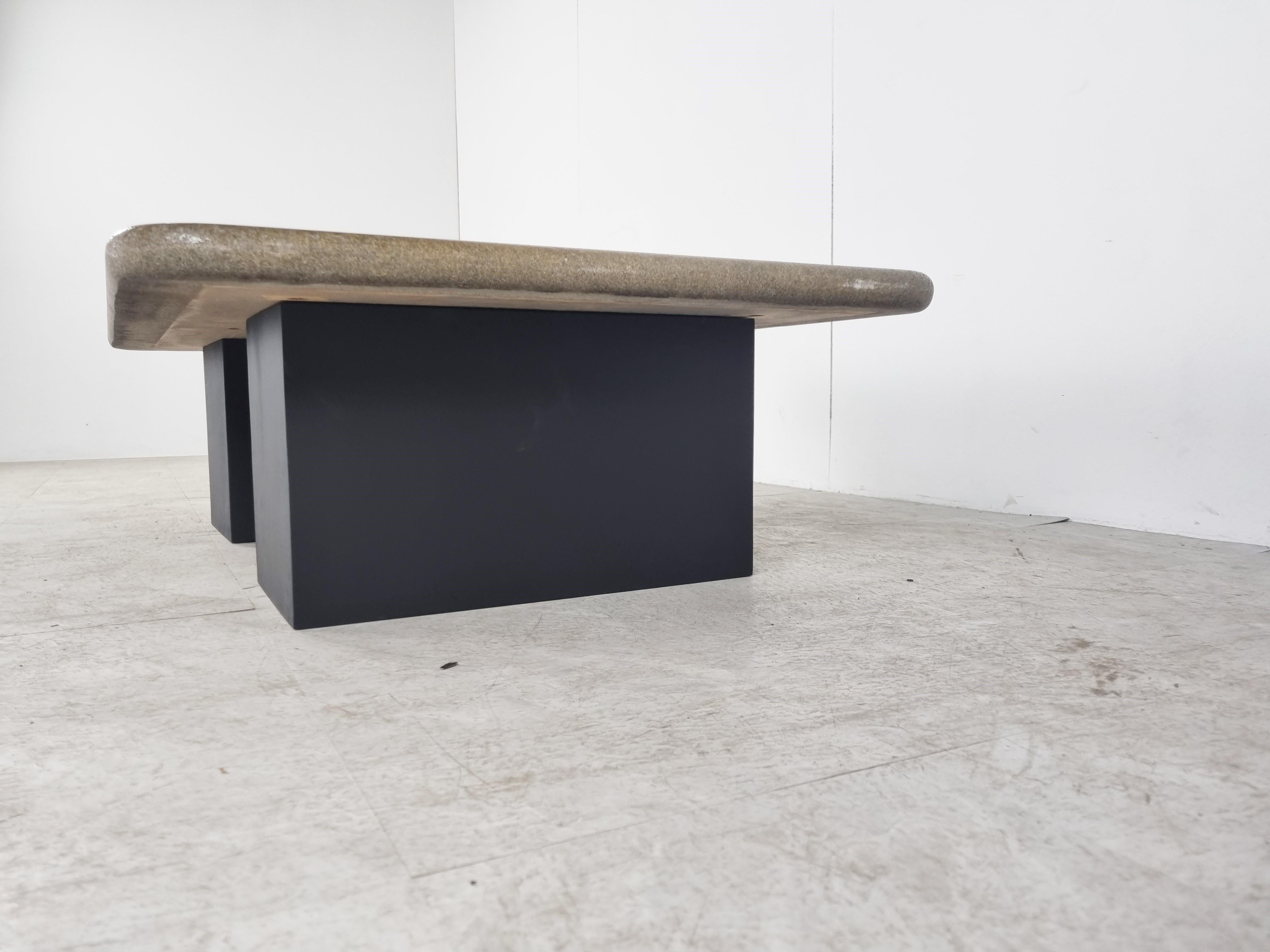 Table basse brutaliste en pierre d'ardoise avec un effet 3D.

Double base en bois.

Signé par 