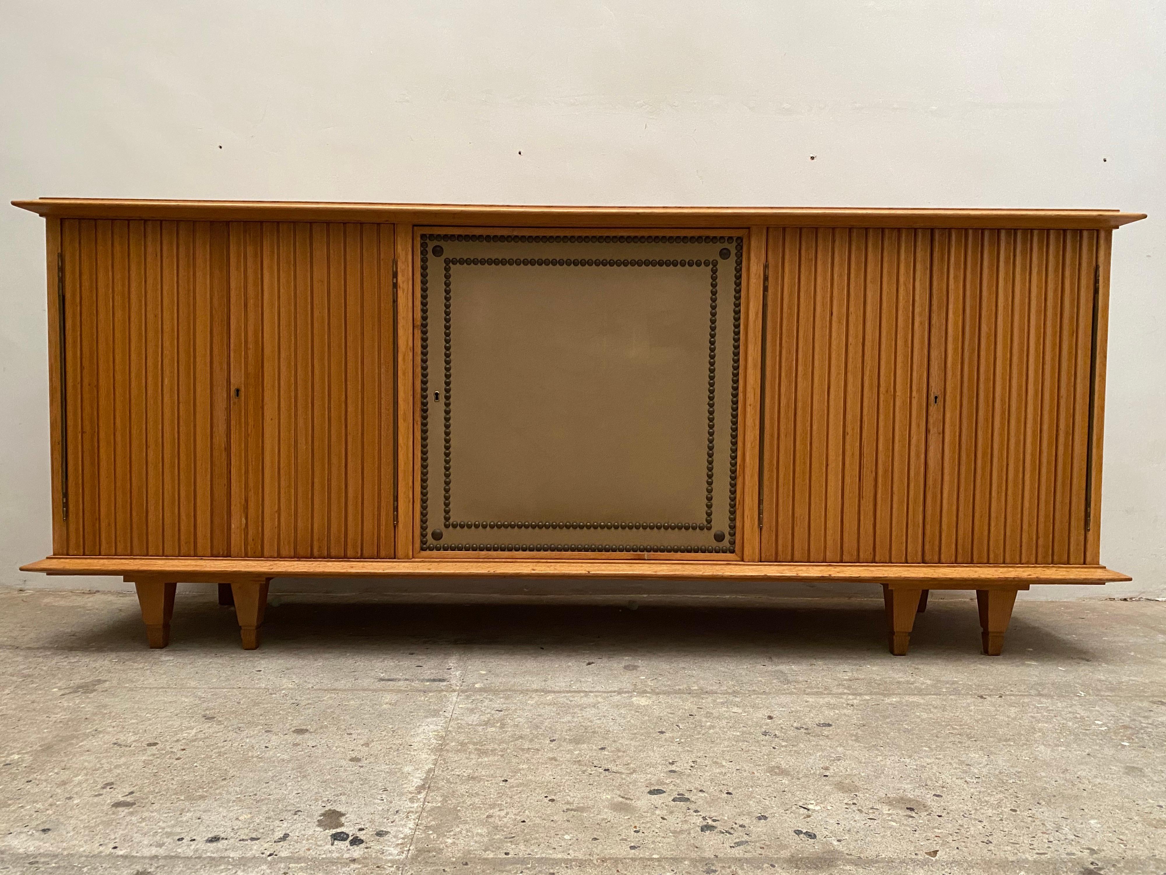Außergewöhnliches Möbelstück aus Eiche und Eichenfurnier, sehr leicht geschliffen. Sideboard für eine Galerie, einzigartiges Stück von De Coene, 1940er Jahre. Der rechteckige Korpus ruht auf doppelten Eckbeinen und hat eine konturierte Platte mit