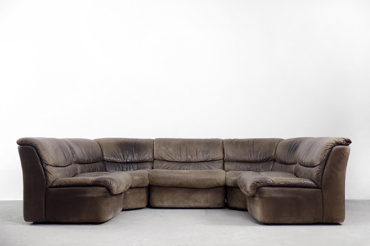 This modular, leather sofa was produced by the German Musterring manufacture during the 1960s. The sofa is completely upholstered in dark brown natural leather. It consists of five modules, including two corner ones. This configuration gives many