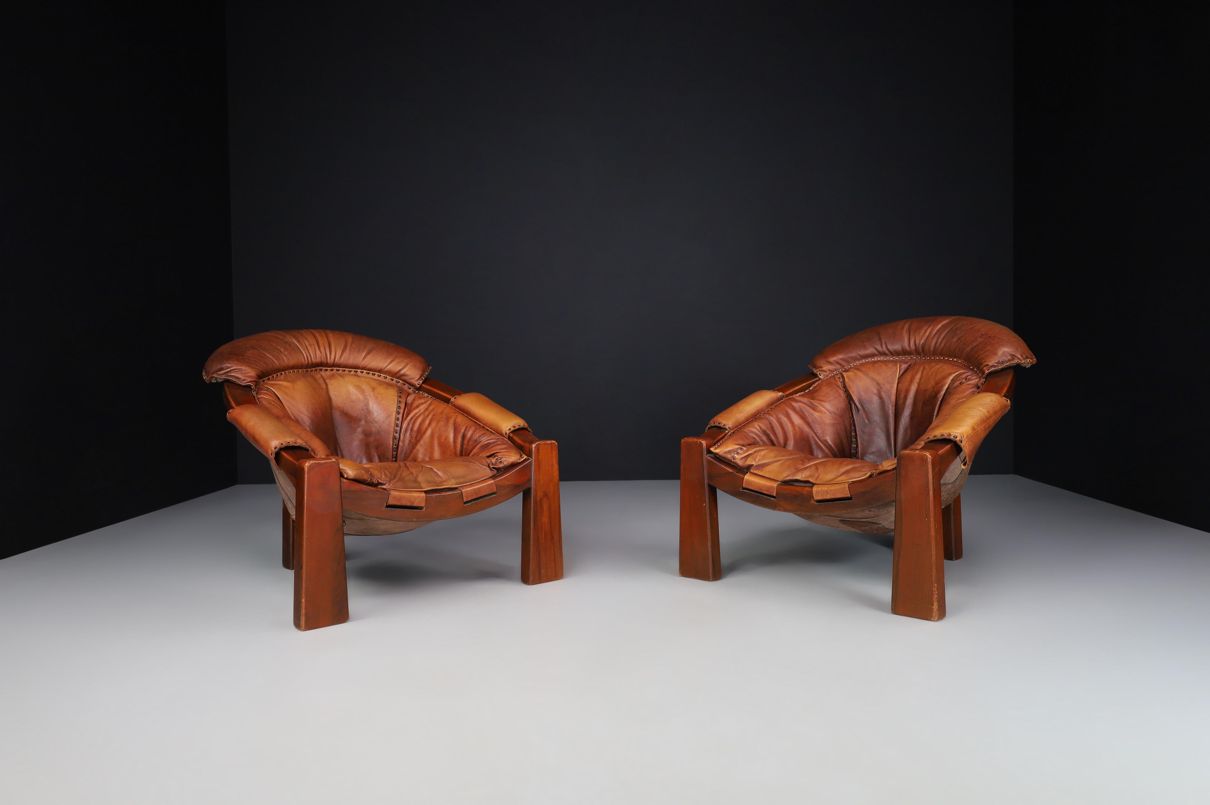 Brutalist Luciano Frigerio patinated cognac leather lounge chairs, Italy, 1970s

Luciano Frigerio created these Brutalist lounge chairs in Italy in the 1970s. These chairs have a solid walnut frame, a thick cognac leather seat, and a fantastic