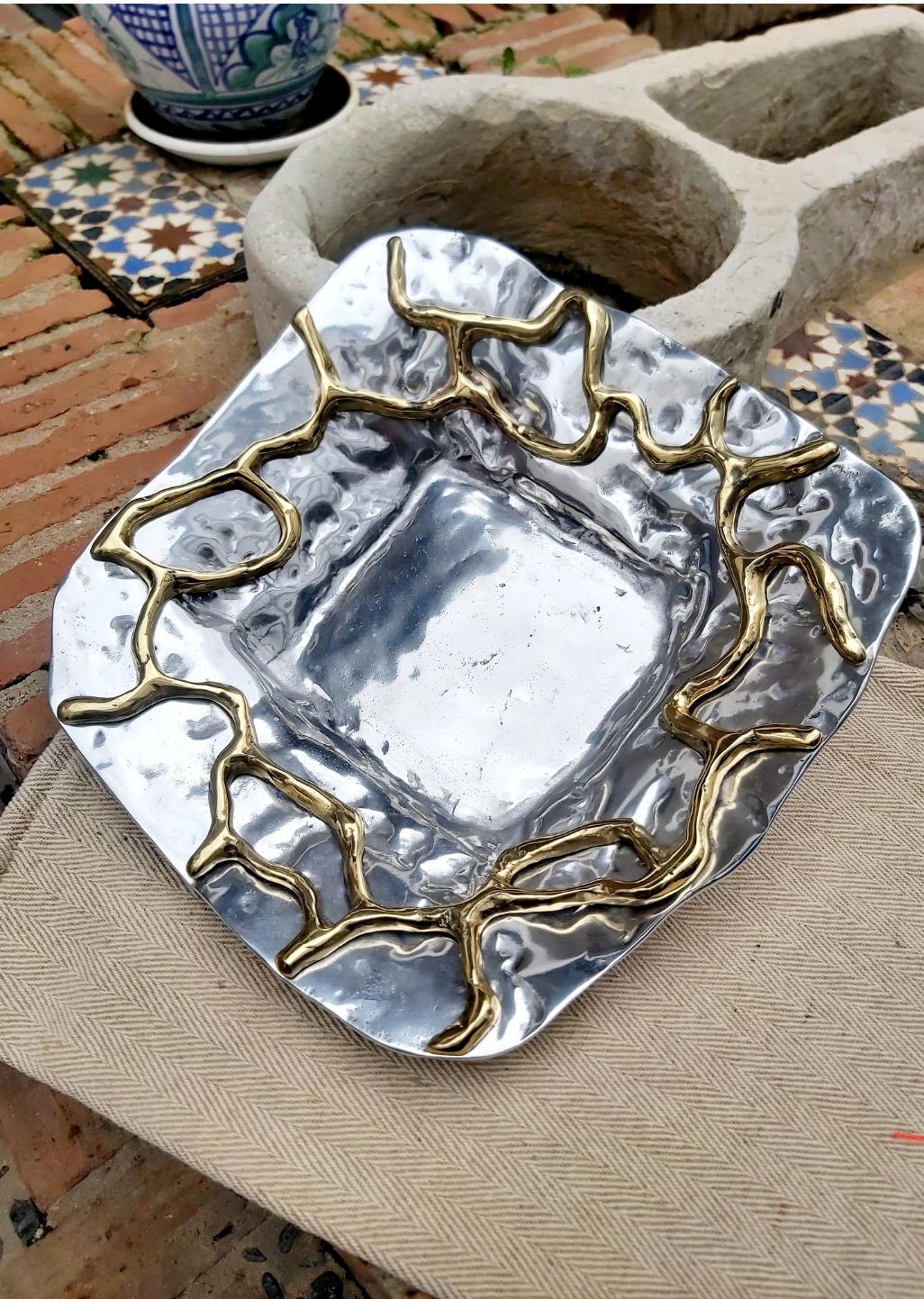 The abstract bowl was created by David Marshall, from sand cast aluminium.
 We use recycled materials all our pieces are handmade, mounted and finished in our foundry and workshop in Spain.
It is certified authentic by the Artist David