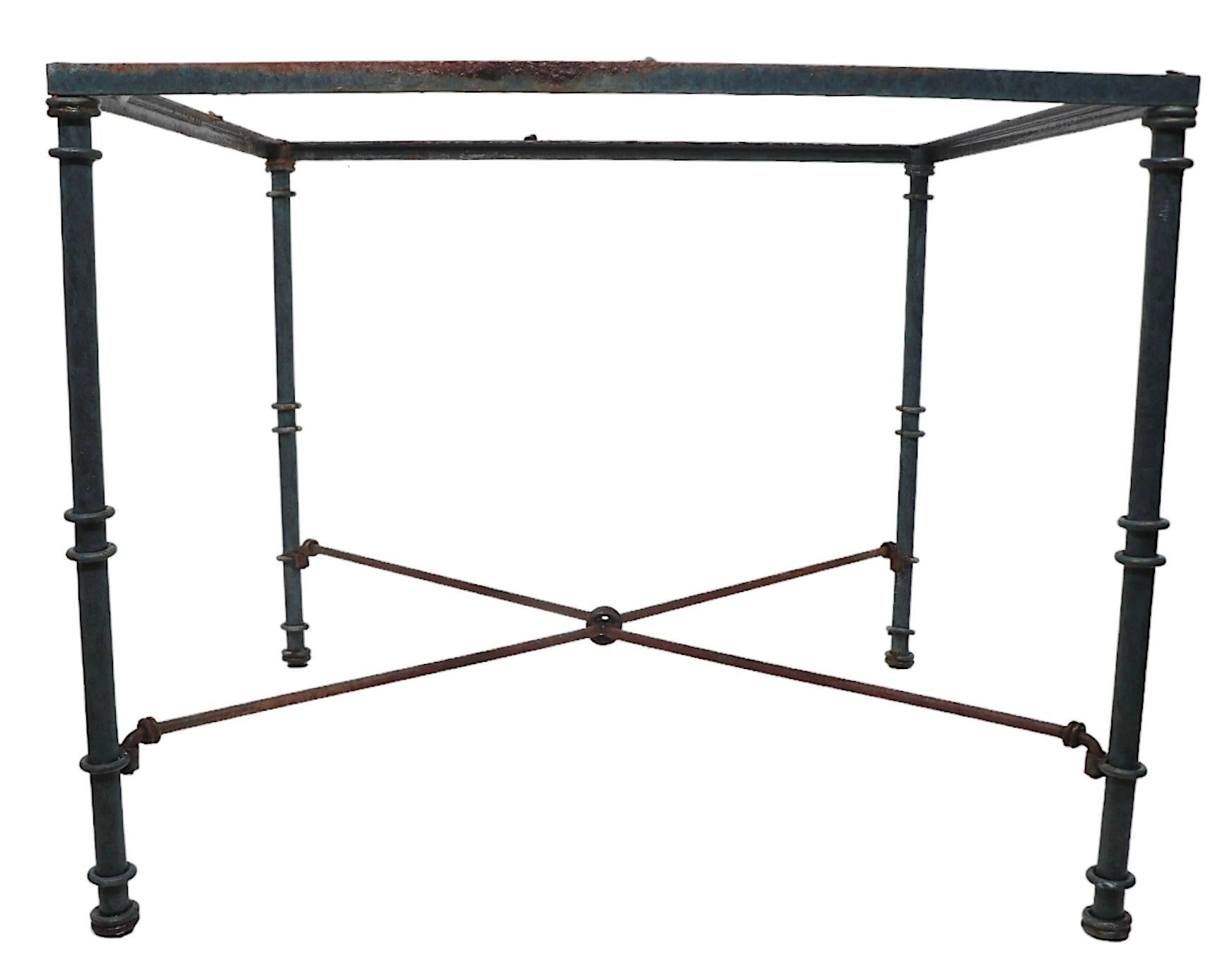 Comedor de estilo Brutalista Chic, Románico, Antigüedad Clásica  Mesa de metal tubular con anillas decorativas, un bastidor en forma de X,  y tapa original de cristal templado. La mesa es estructuralmente sólida y robusta, el acabado muestra cierto