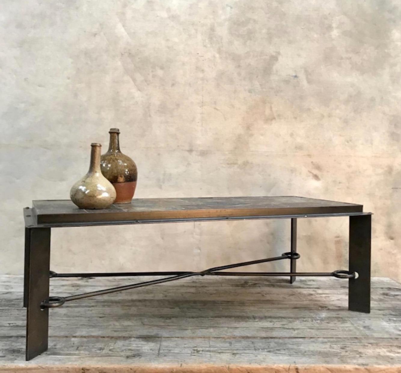 Low rectangular coffee or console table with incredible metallic lava rock top and industrial burnished metal framework. Four sharp angular legs are connected by an X-shaped stretched with interesting hook attachments. A wonderful example of French