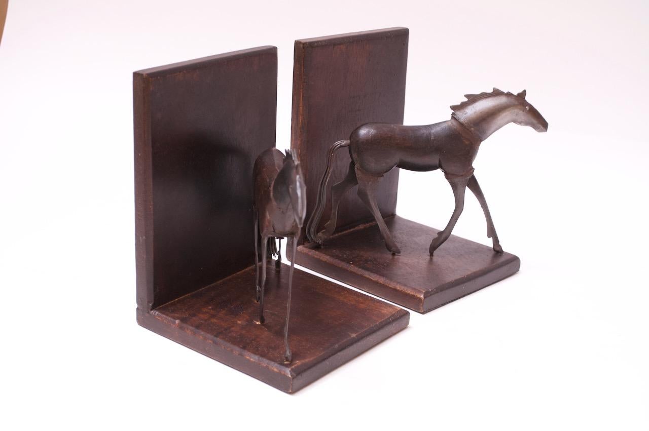 Unique circa 1970s, USA Brutalist-style horse bookends composed of cut and soldered sheet metal heads and legs with carved wooden bodies and wire tails. Very good, vintage condition, with minor wear consistent with age / use.