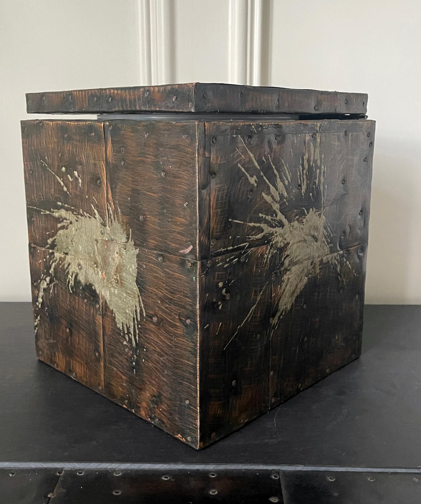 A cube form desktop box covered with patchwork copper by American artist and designer Paul Evans (1931-1987). The lidded box has a plastic insert box and was made as an ice box or a wine cooler. The iconic surface showcases the metal sheet patchwork