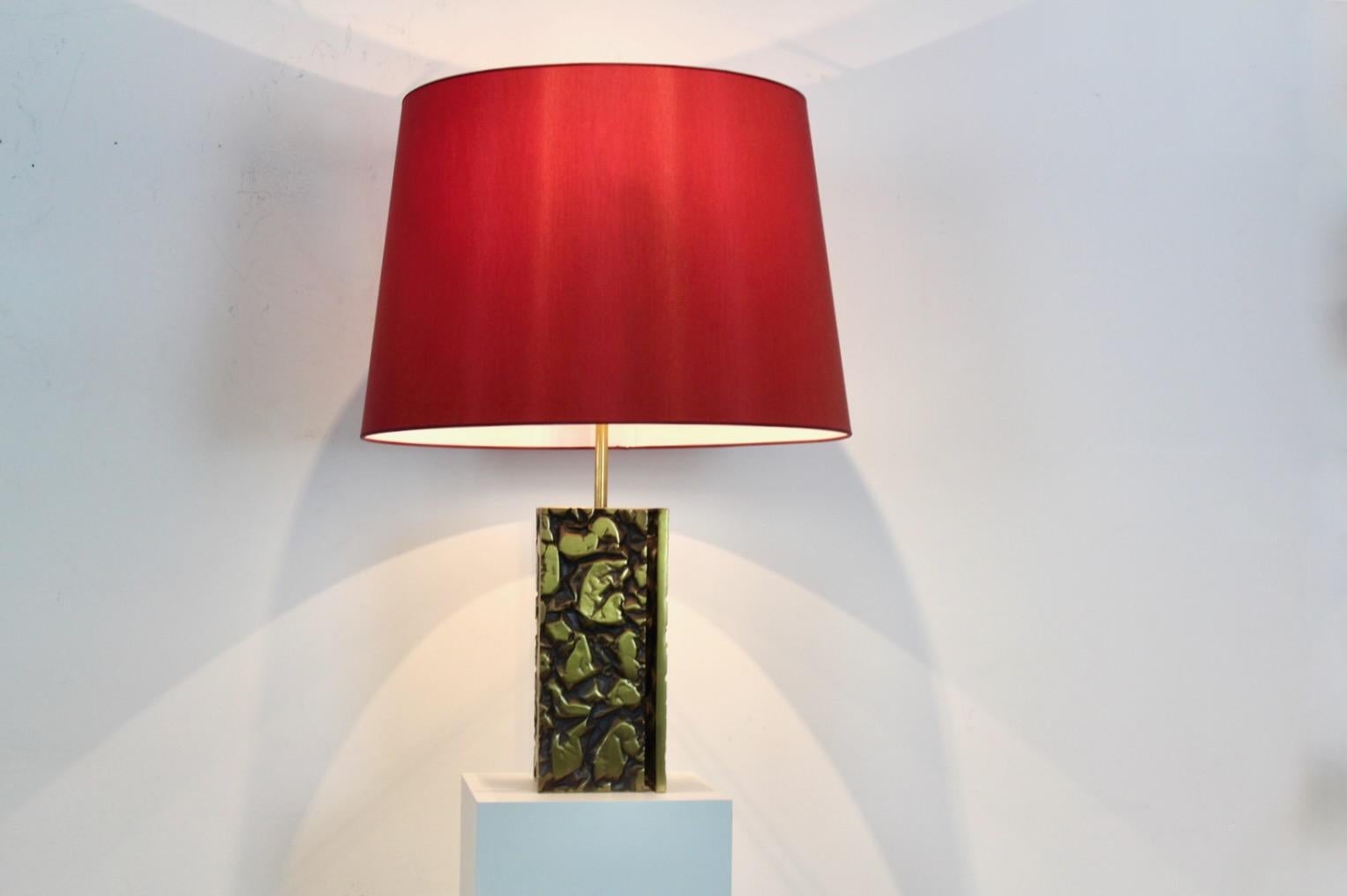 Expressive Brutalist table lamp made in France in the 1970s. Beautiful Heavy and Large lamp base with Bold Abstract Brass Sculptured accents. Comes with a matching shade. Very good vintage condition with normal wear. Beautiful lighting effect.