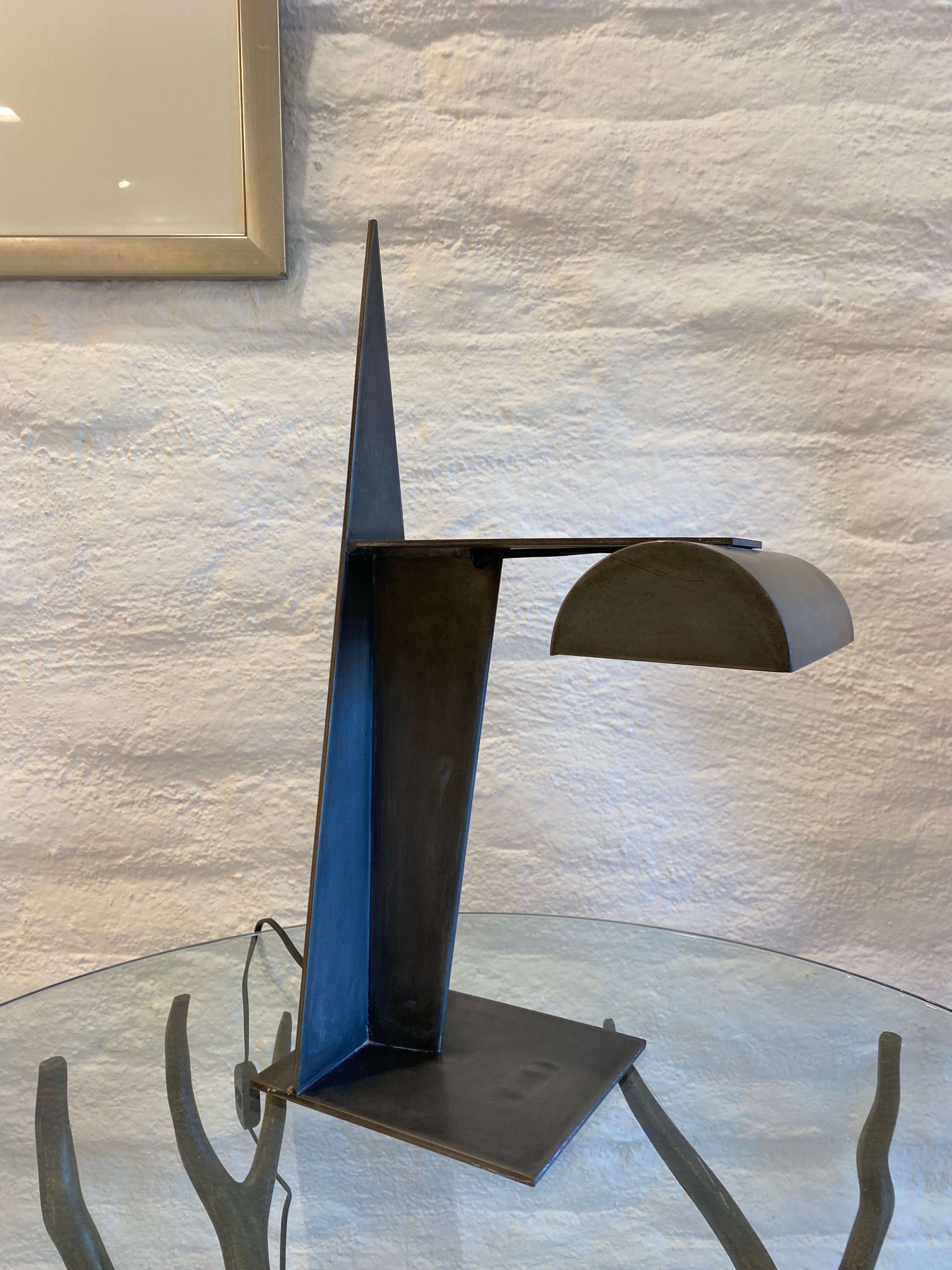 This is a wonderful brutalist metal task lamp. This lamp is styled after Gino Sarfatti's Rodchenko inspired lamp. Inspired by Aleksandr Rodchenko's stage design for Inga (1929), Gino Sarfartti produced a task lamp for Arteluce in the early 1970s.