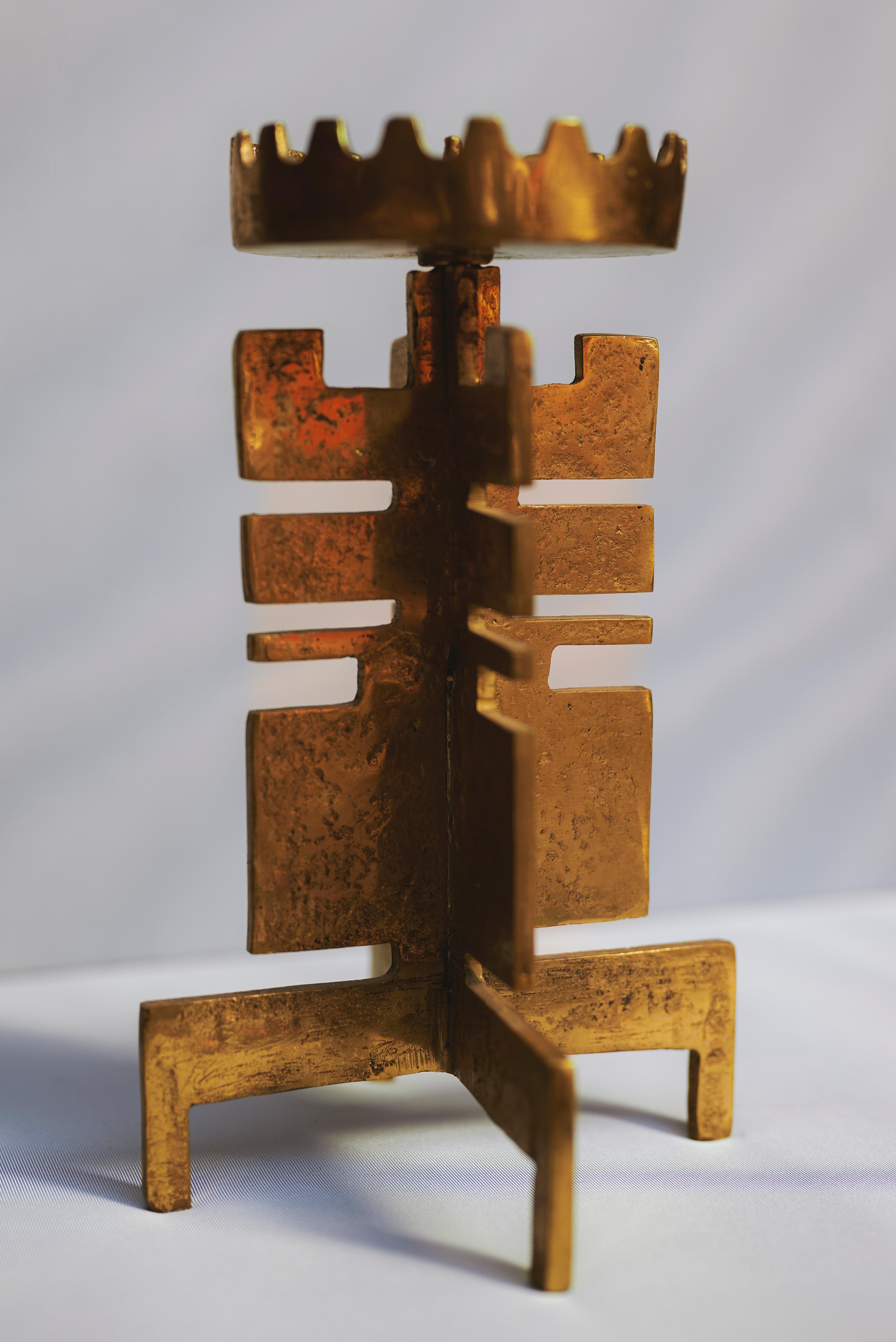 Candelabro brutalista in ottone fuso a mano dell'artista austriaco Heinz Goll, creato negli anni Sessanta. Questo raro pezzo scultoreo presenta 1 portacandela che si erge da una base strutturata, evocando oggetti rituali e forme totemiche. La