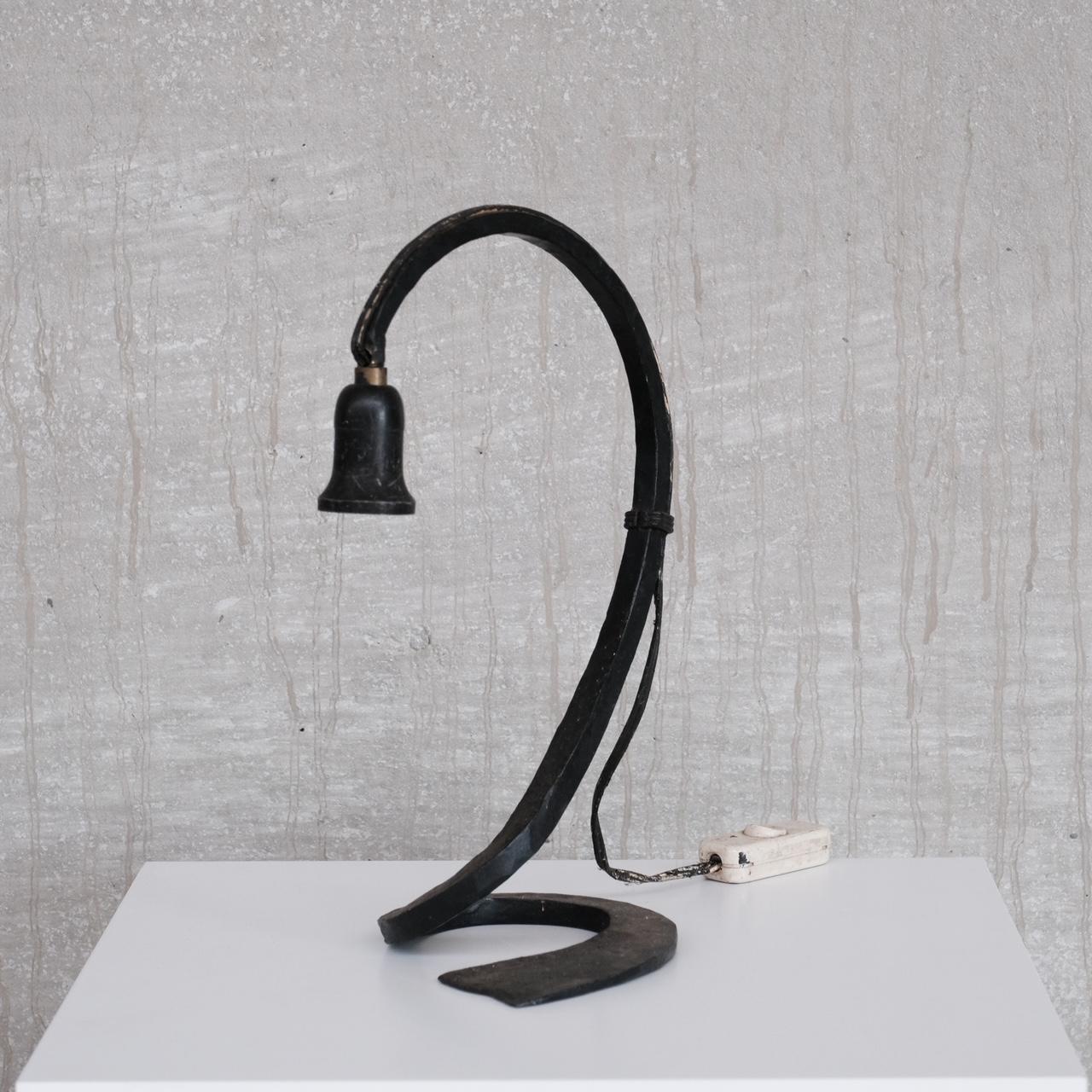 An elegant forged iron table lamp. 

France, c1950s. 

Brutalist style but with more elegant designed curves. 

Since re-wired and PAT Tested. 

Good vintage condition. 

Location: Belgium Gallery. 

Dimensions: 36 H x 15 W x 22 D in cm.