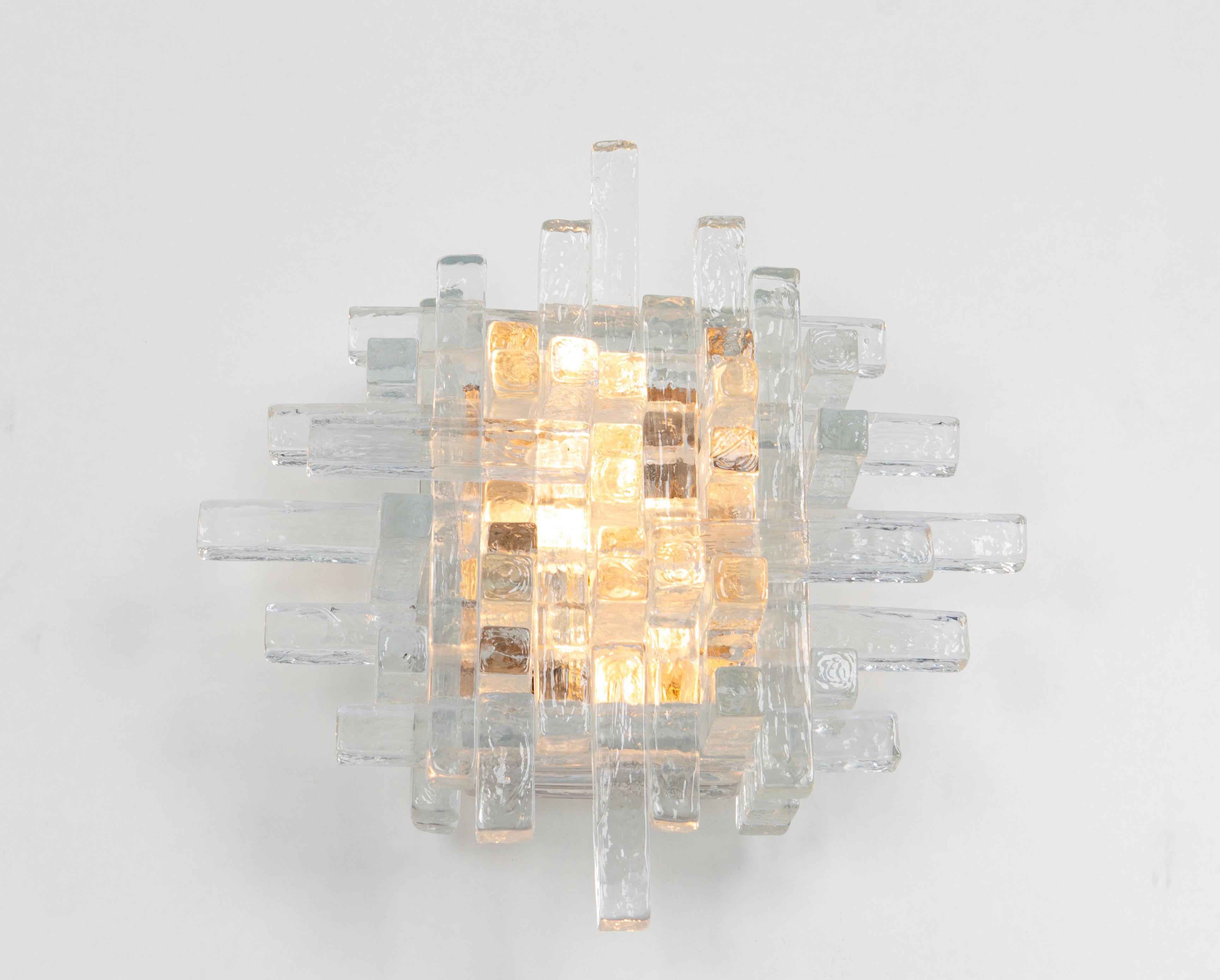 Brutalist mid-century wall sconce sconce by Albano Poli for Poliarte, 1970s
Poliarte Italy, sconce / wall applique, 1960s. 
It's composed of dozens of glass rectangles of different sizes stacked together. The glass is clear but textured. Holds two