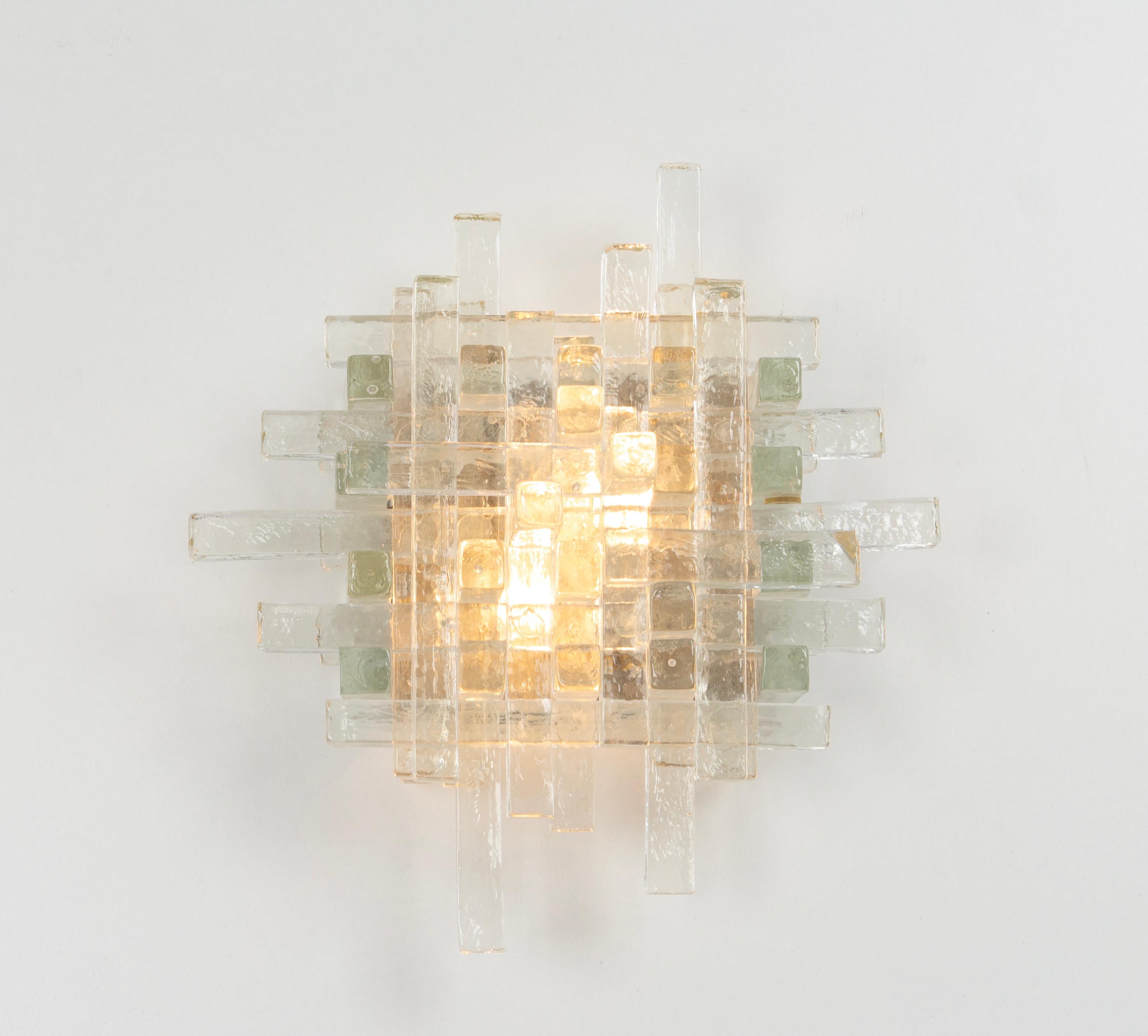 Brutalist mid-century wall sconce sconce by Albano Poli for Poliarte, 1970s
Poliarte Italy, sconce / wall applique, 1960s. 
It's composed of dozens of glass rectangles of different sizes stacked together. The glass is clear but textured. Holds two