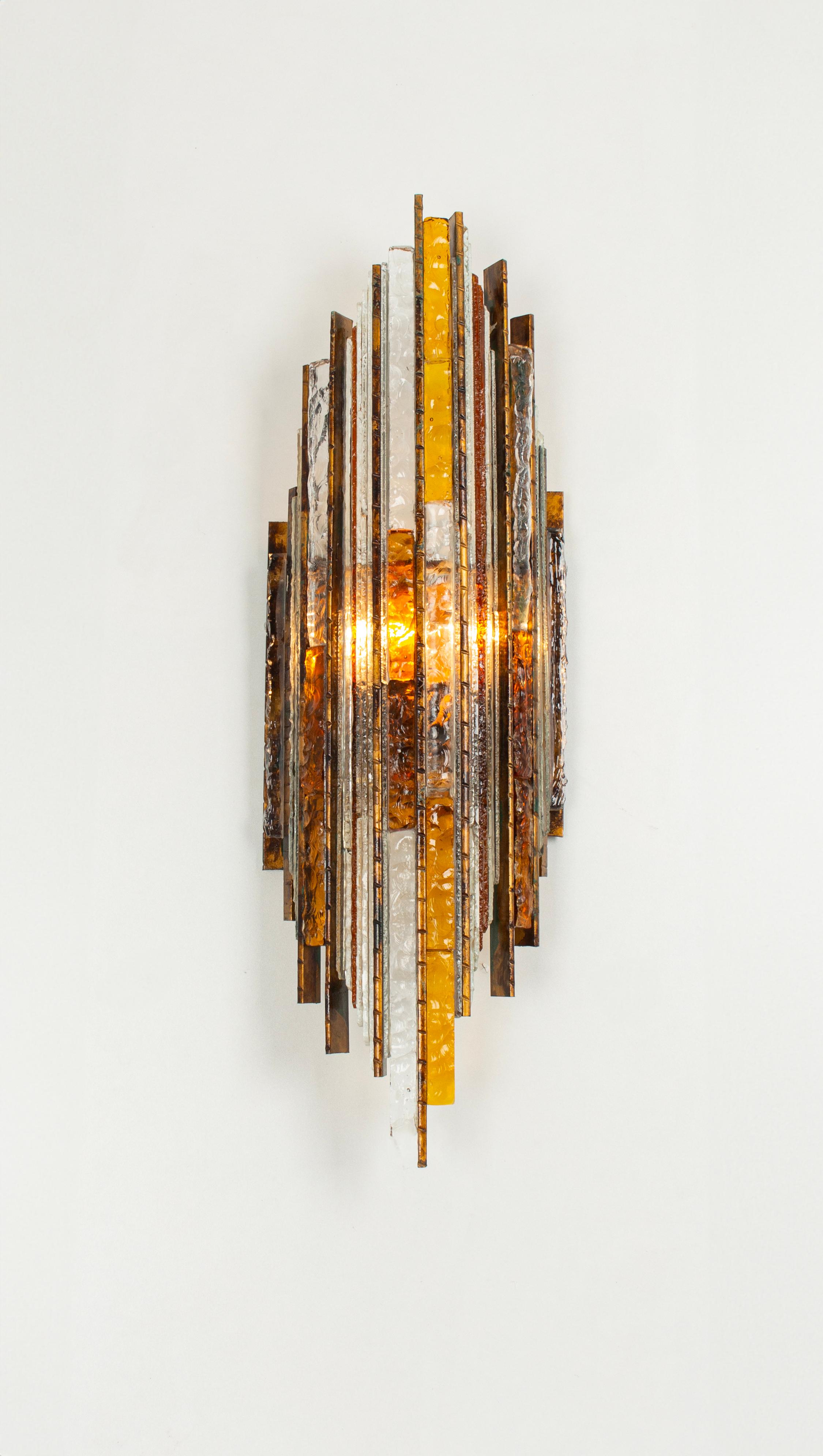 Brutalist mid-century wall sconce sconce by Albano Poli for Poliarte, 1970s
Poliarte Italy, sconce / wall applique, 1960s. Structure of iron with the surface in patina look, differently colored glass elements, with two light outlets.
Sockets: Two x