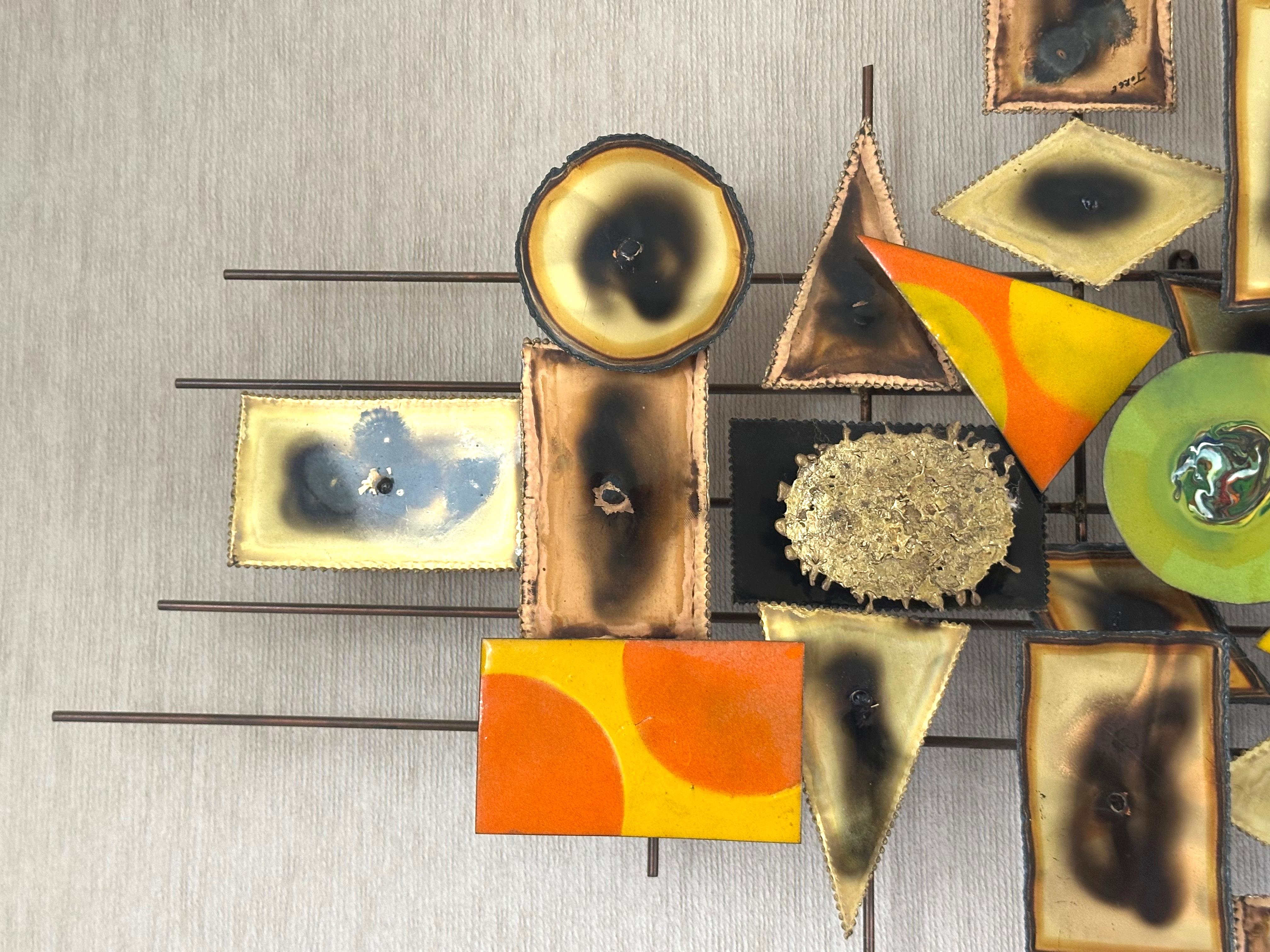 A striking and dimensional Brutalist wall sculpture by the artist Jorge, signed and dating to the 1970s. This unique mixed-metal composition features an intricate arrangement of brass, copper, and enameled metal elements, skillfully layered and