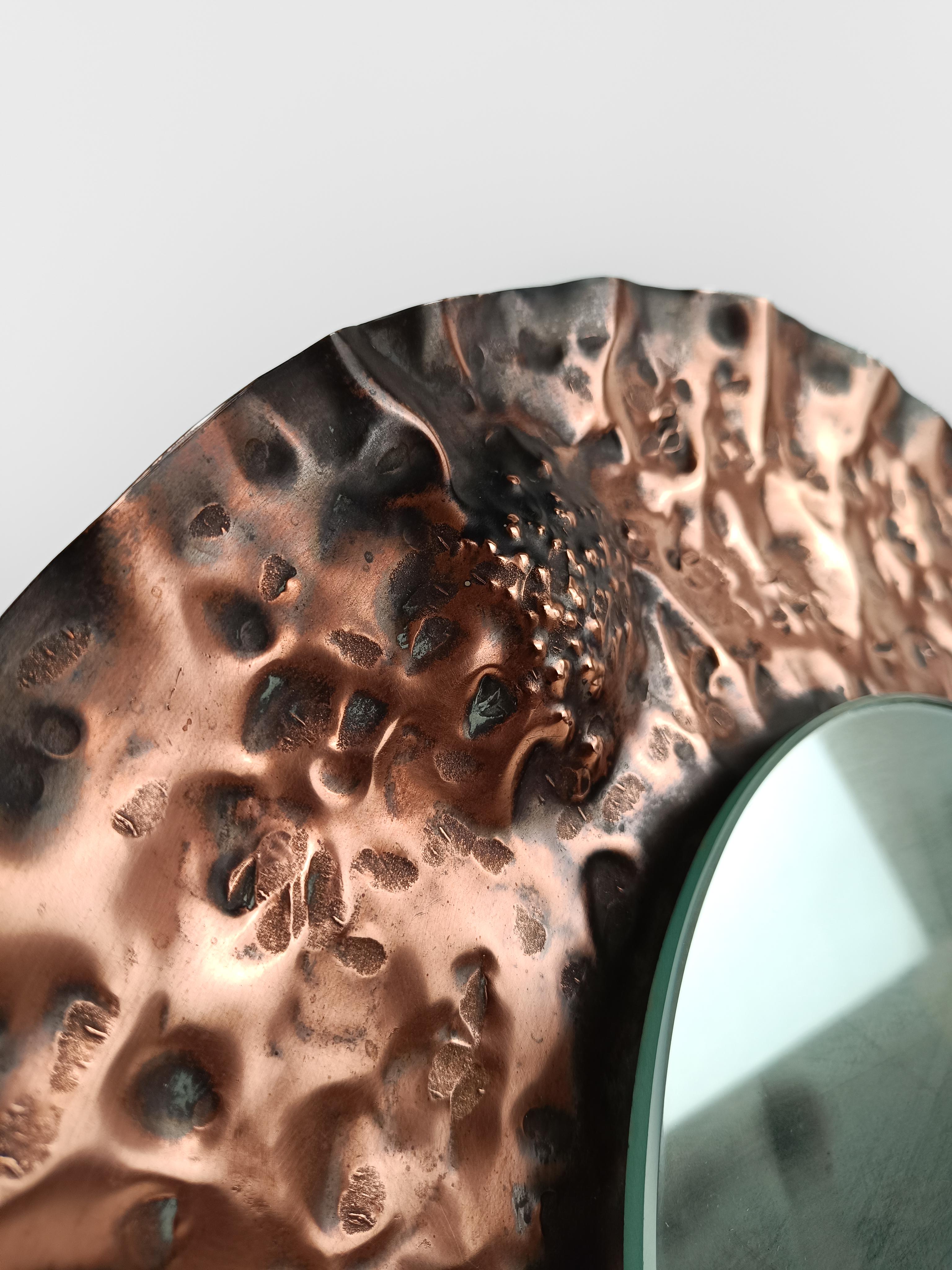 A mid-century mirror with an unusual and sinuous shape, the circular shape becomes three-dimensional, rising and falling, creating waves and craters just like the lunar surface.
This vintage mirror is made in Italy between the 50s and 60s and