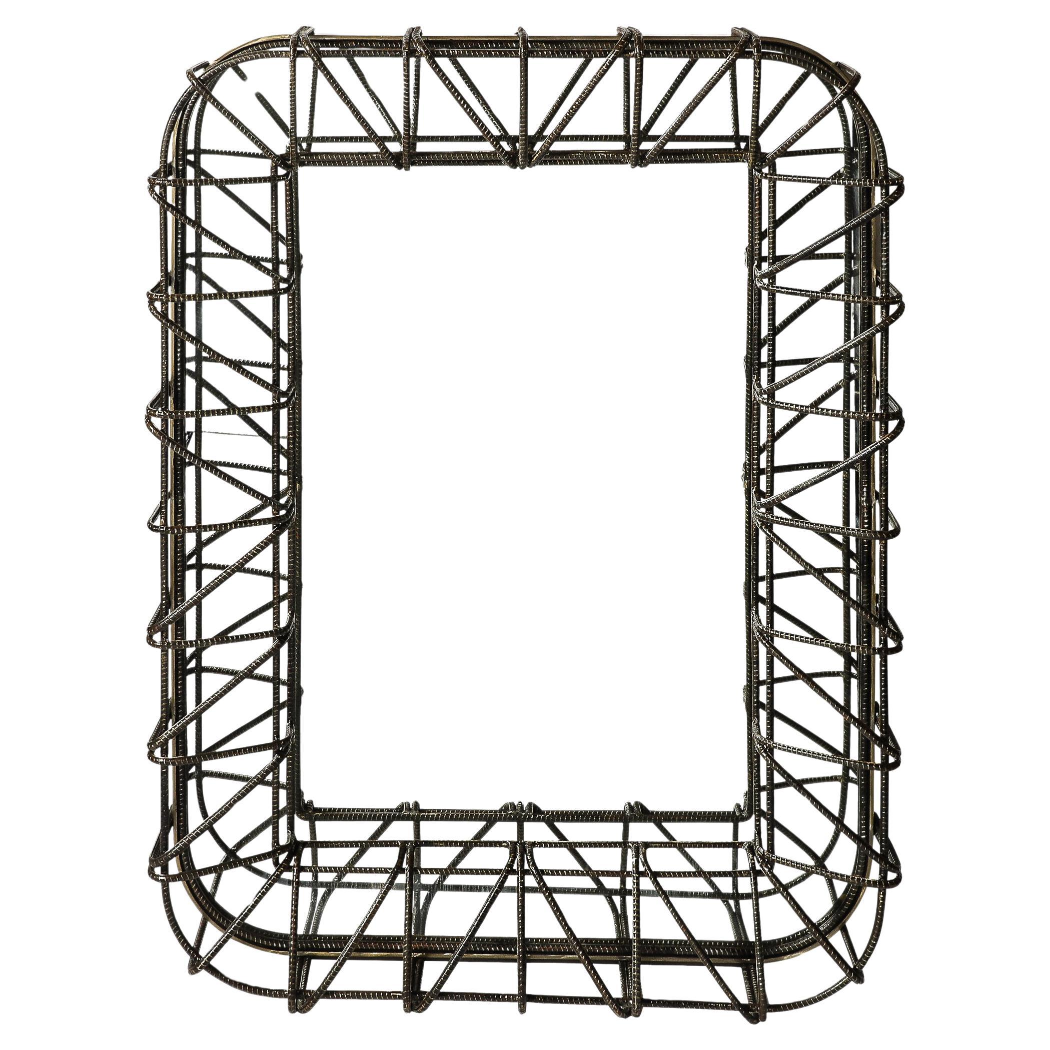 This unique and impactful Brutalist Mirror in Sculptural Welded Rebar originates from the United States during the 20th Century. Features a dimensional border formed in welded curved elements of rebar, with striated textural detailing and rounded