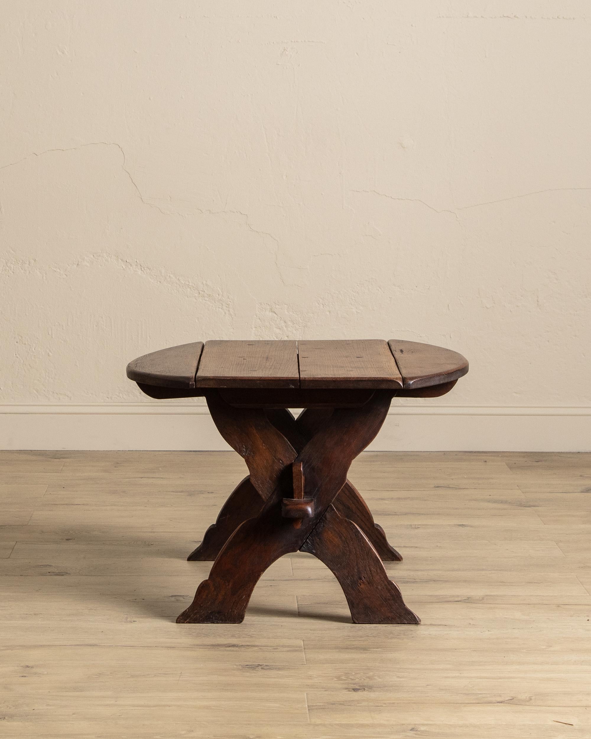 Cette table d'appoint de style brutaliste français, fabriquée en chêne rustique vers les années 1960, présente une base distinctive en forme de X et un assemblage traditionnel à tenons et mortaises qui mettent en valeur sa construction artisanale.