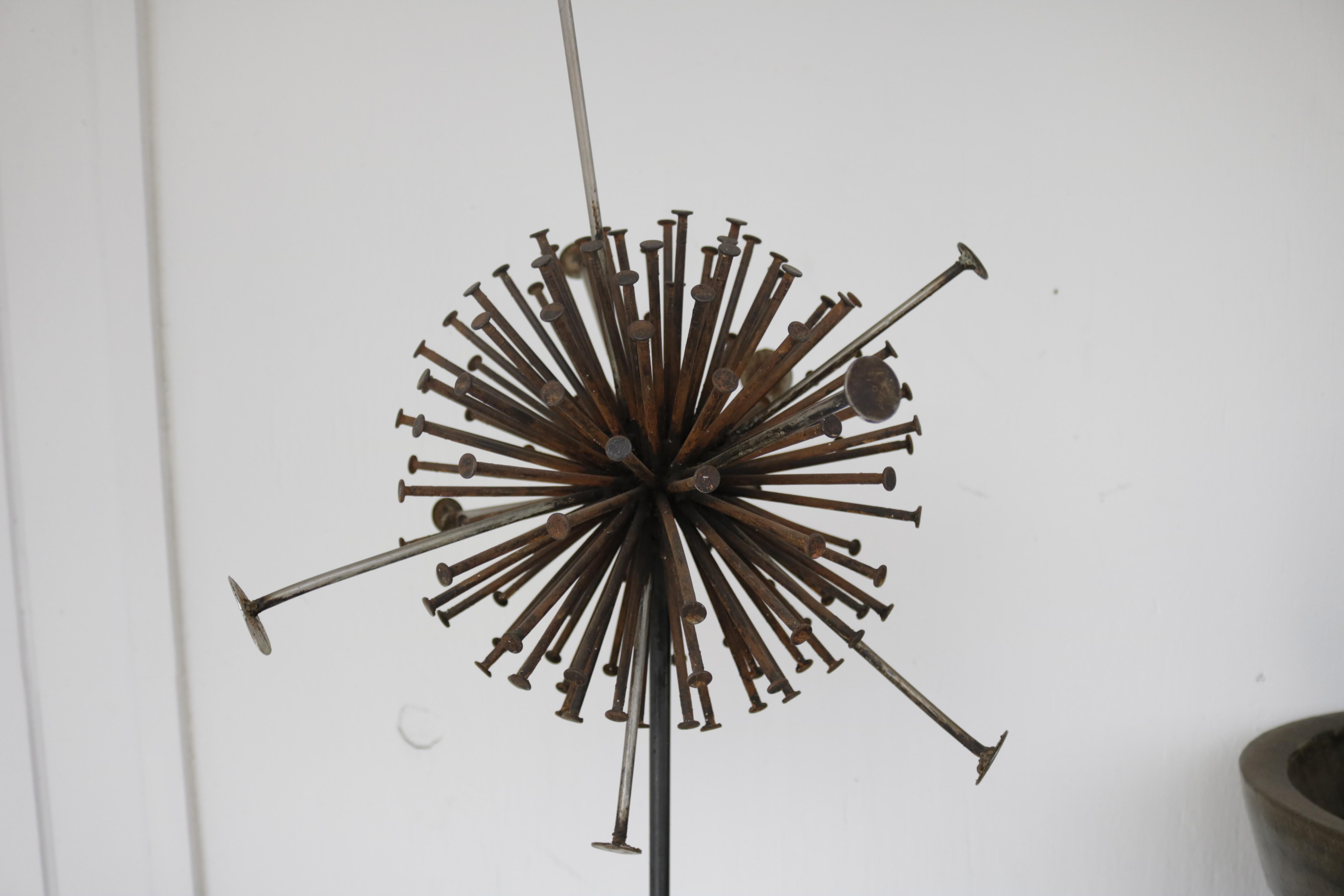 This brutalist metal round sculpture has an amazing patina and a very modern feel. The piece, composed of rusted nails, steel, and a wood base is heavily influenced by Brutalist aesthetics.