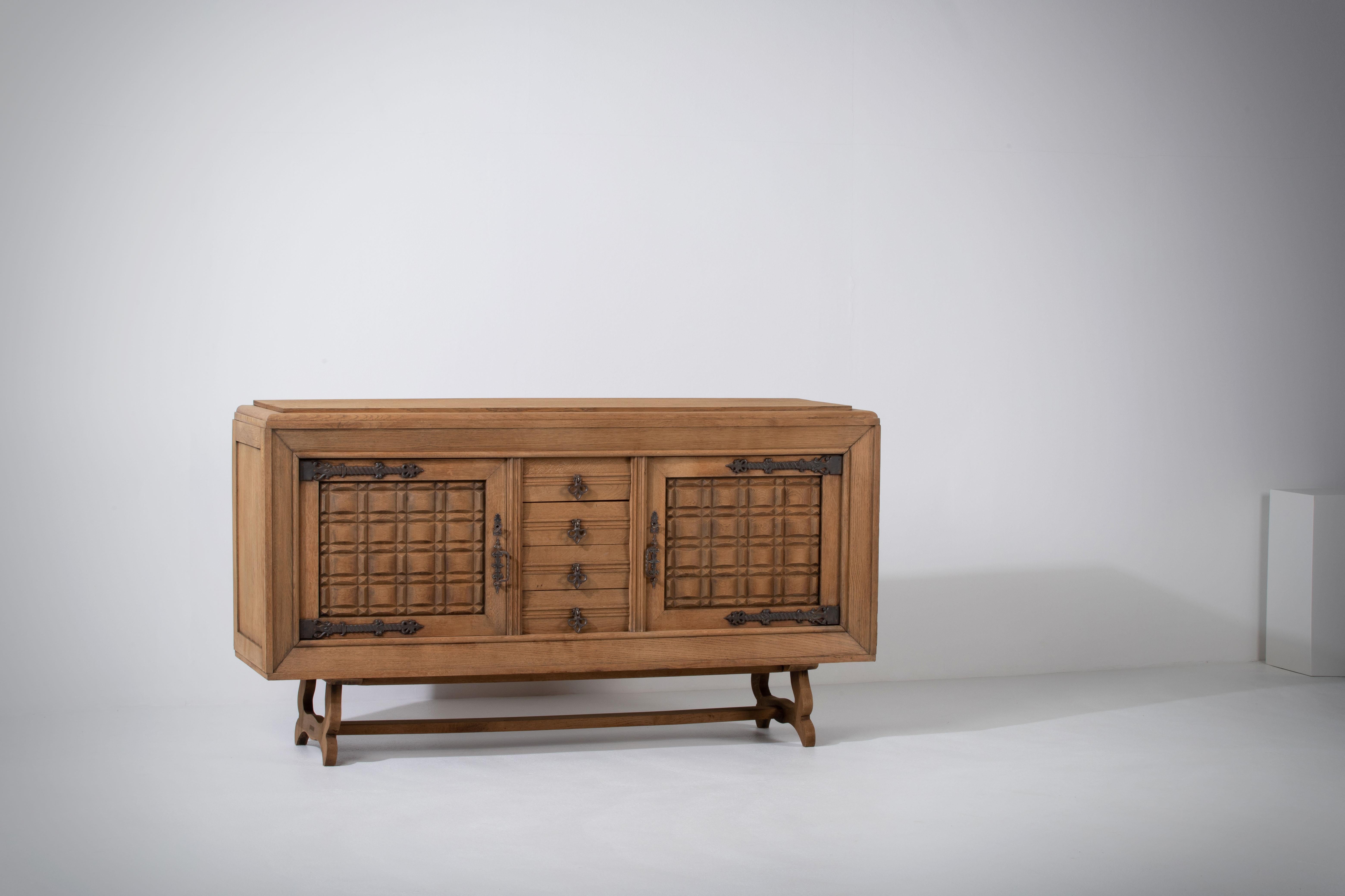 Presenting an exquisite Brutalist sideboard from the 1940s, crafted with natural oak in France. This elegant piece showcases the unique blend of ruggedness and refinement that defines the Brutalist style. The sideboard features intricately carved