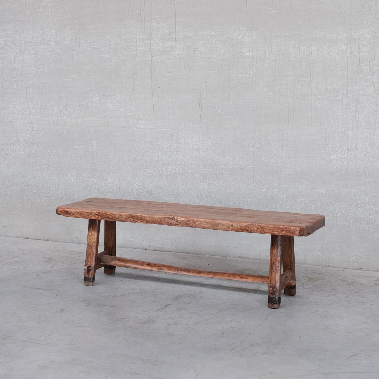 A brutalist wooden coffee table with iron details. 

France, c1950s. 

Of primitive brutalist style. 

Good condition, some scuffs and wear commensurate with age. 

Location: Belgium Gallery. 

Dimensions: 138 W x 46 D x 43 H in cm.