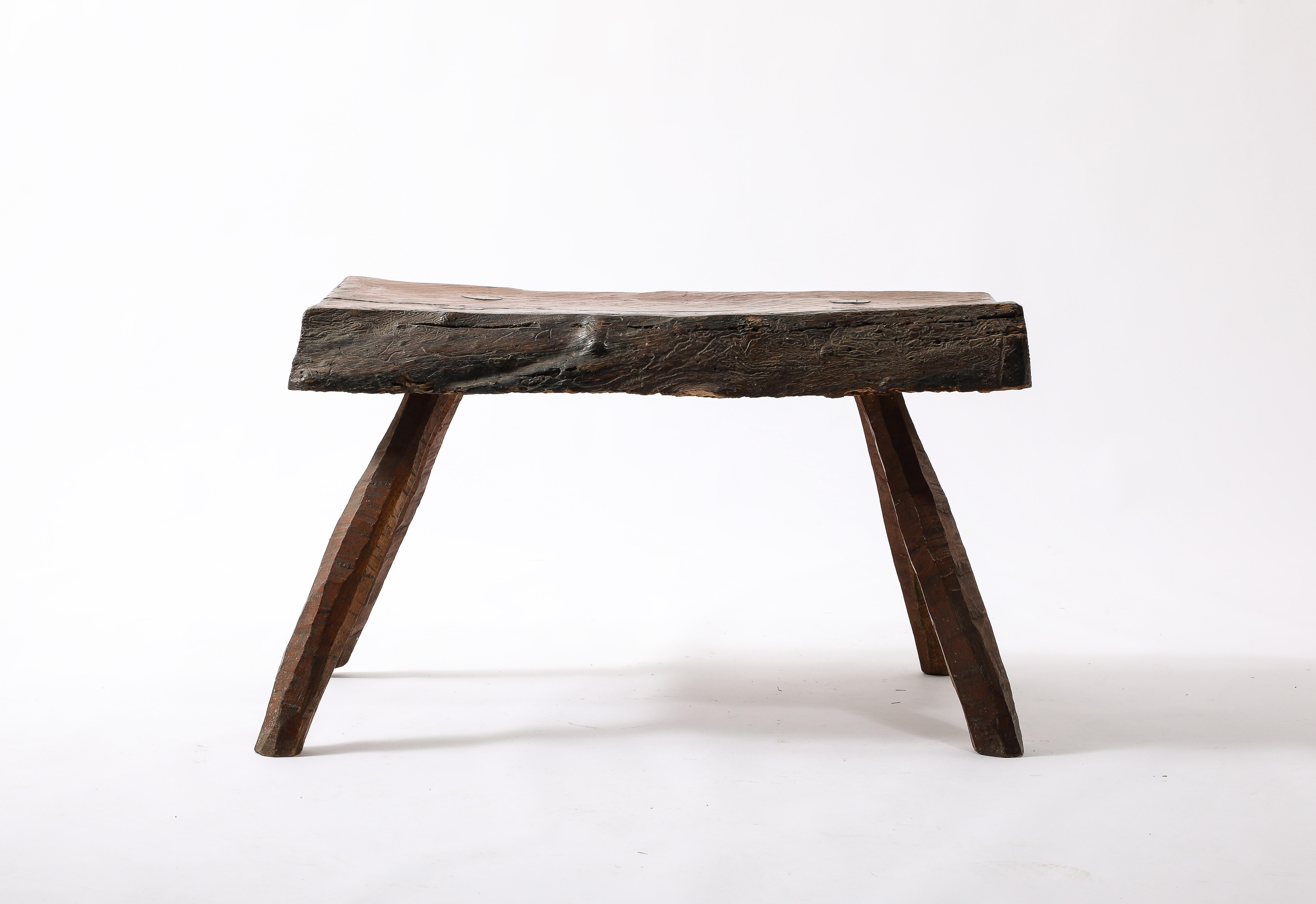 Thick hand cut oak bench on splayed legs in original patina.

