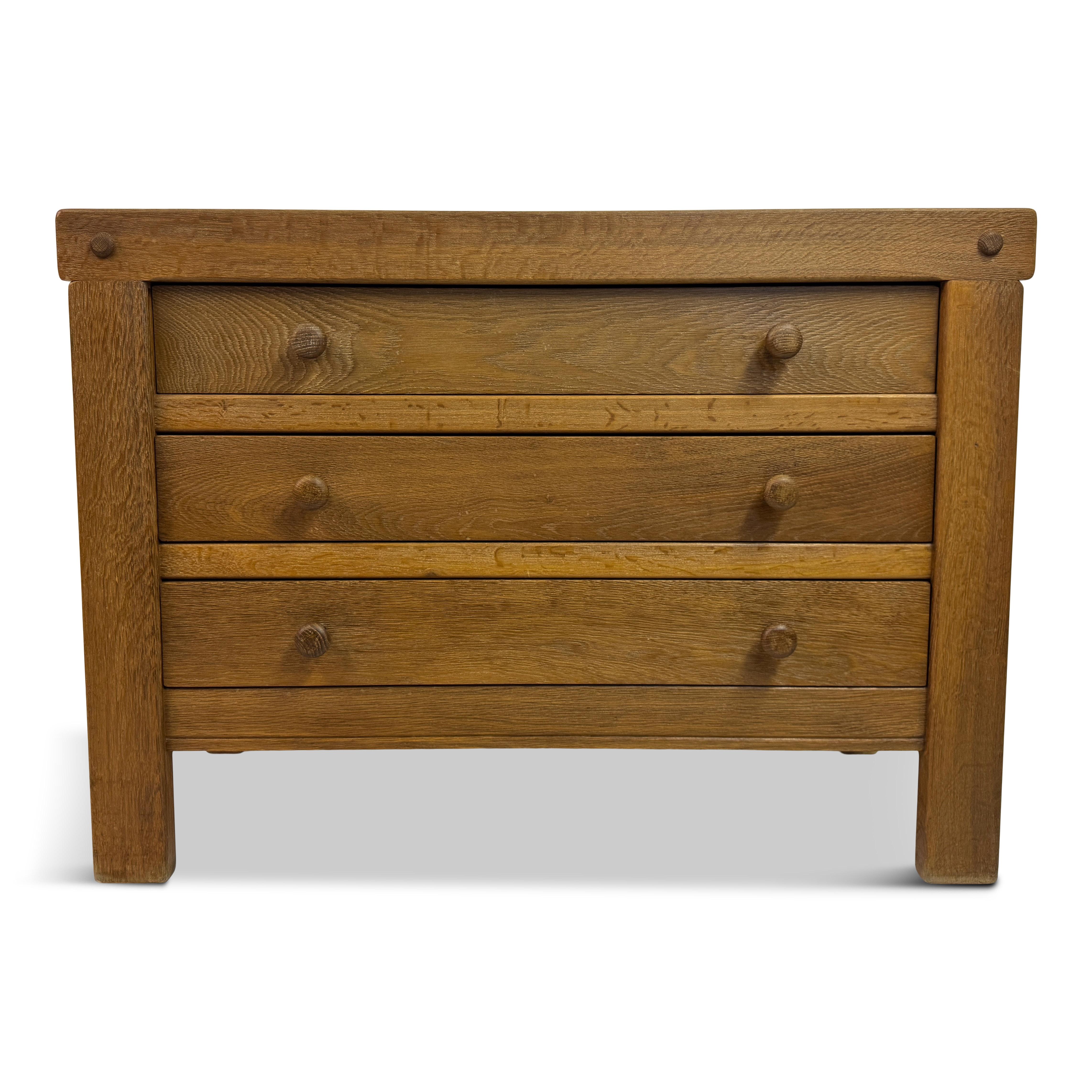 Brutalist Oak Chest of Drawers, 1970s


A solid and quietly sculptural Brutalist chest of drawers in oak, likely dating from the 1970s. The piece features three wide drawers with simple turned wooden pulls and exposed dowel details at the frame