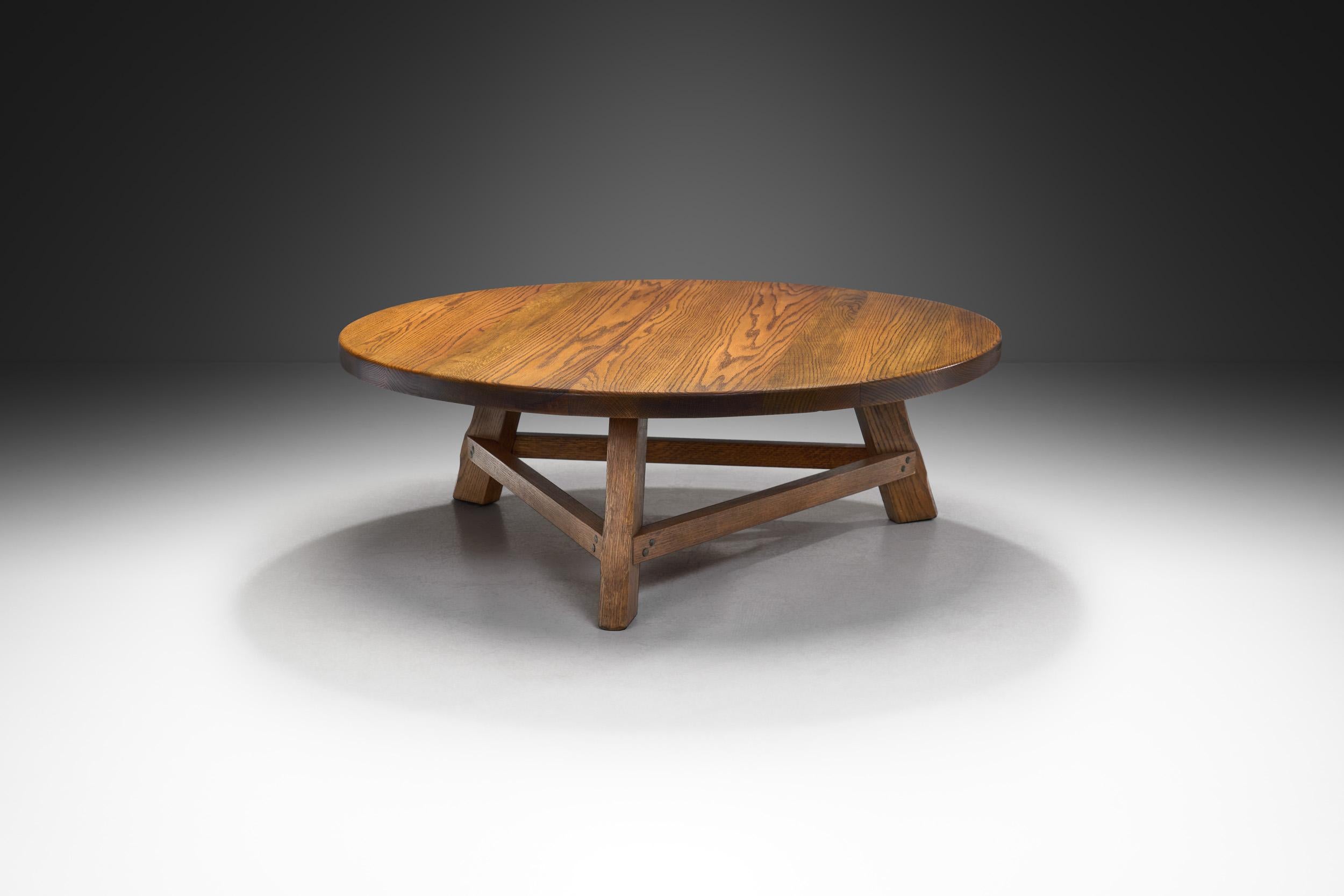 Crafted from a nice warm brown oak wood, this table in many ways epitomizes the Brutalist movement, a design philosophy rooted in raw, unadorned materials and a functionalist ethos.

This piece has a startling rawness, but with its warm-toned, hand