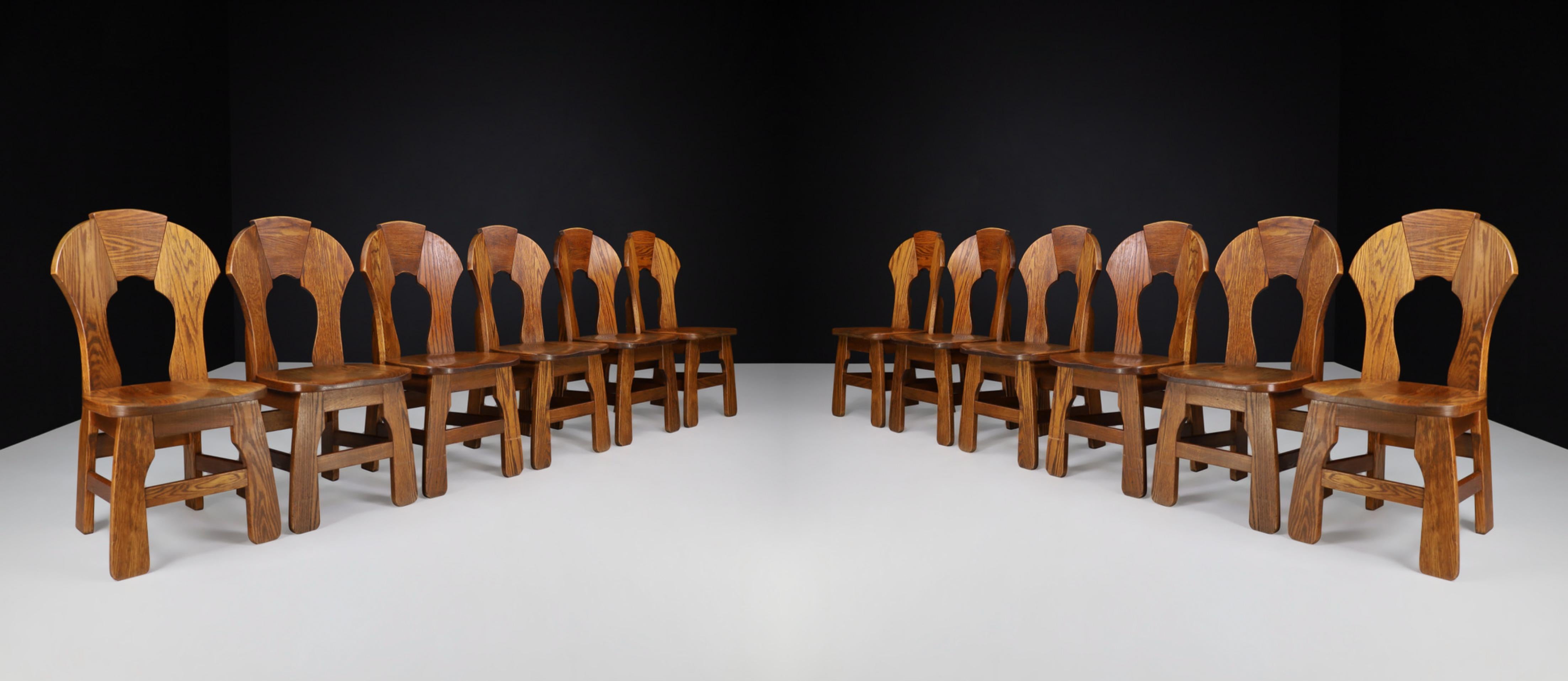 Brutalistische Esszimmerstühle aus Eiche, Frankreich, 1960er Jahre 

Ein umfangreicher Satz von zwölf Eichen-Esszimmerstühlen mit gebogener Rückenlehne, Frankreich 1960er Jahre. Diese brutalistischen Stühle sind vollständig aus massivem Eichenholz