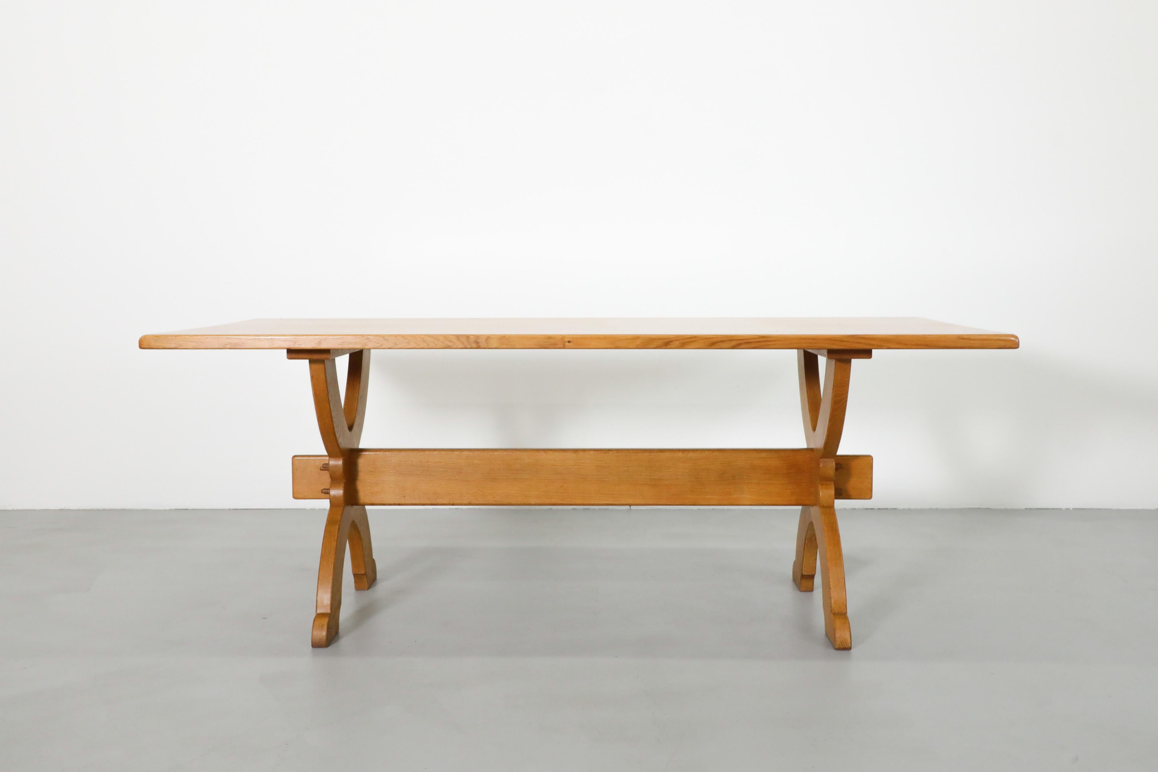 Mid-Century Brutalist oak dining table with X base and cross bar by Bram Sprij and manufactured by Dutch manufacturer Sprij Meubelen Nederland. The company, acclaimed for their well built and sturdy, often beautifully carved pieces existed from 1932