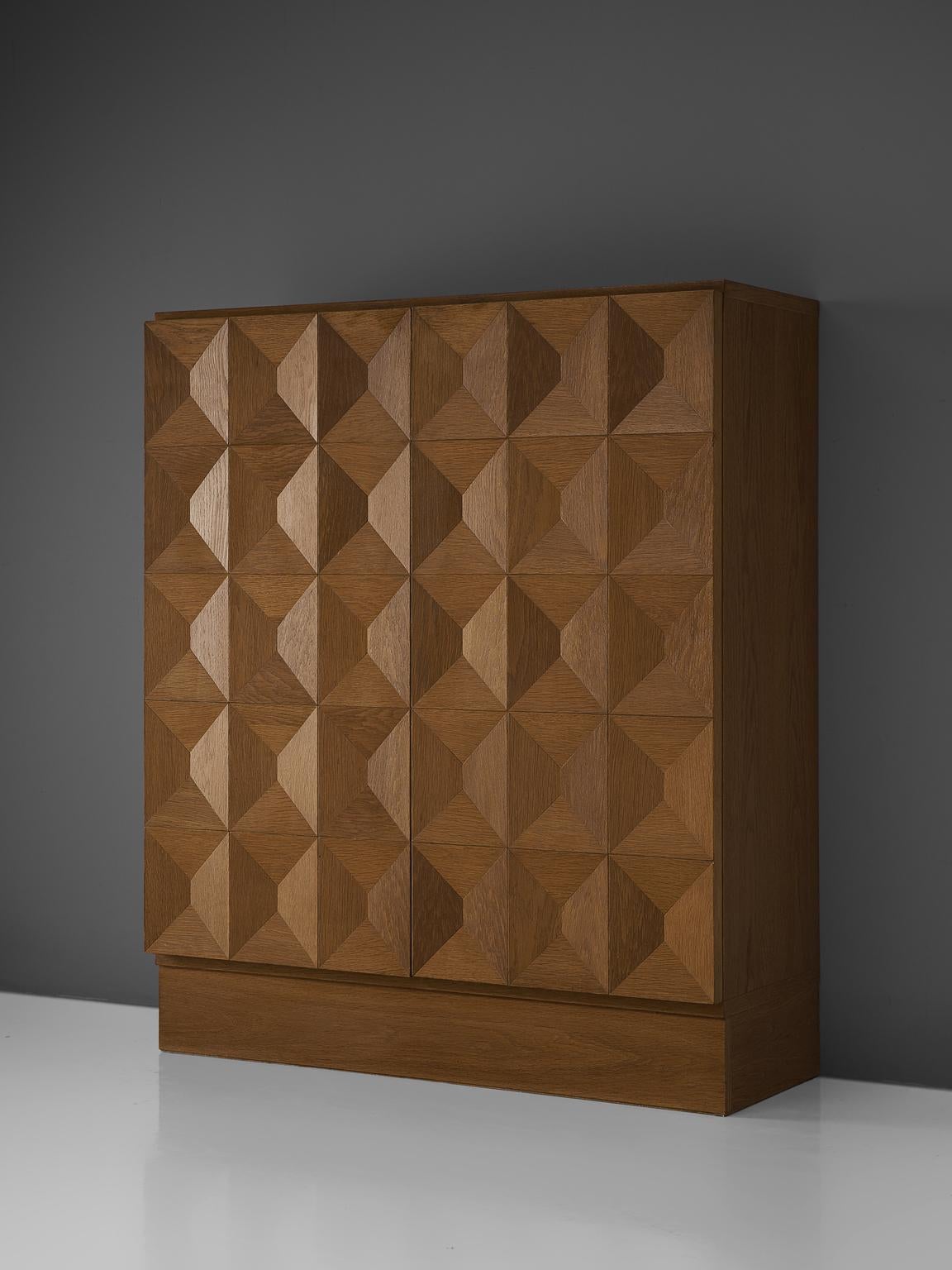 Brutalist cabinet, oak, Europe, 1970s. 

This cabinet with graphical oak cabinet. Two-door panel, each feature an exceptional three-dimensional large pattern. The continuous pattern gives this cabinet a very strong expression, emphasized by the