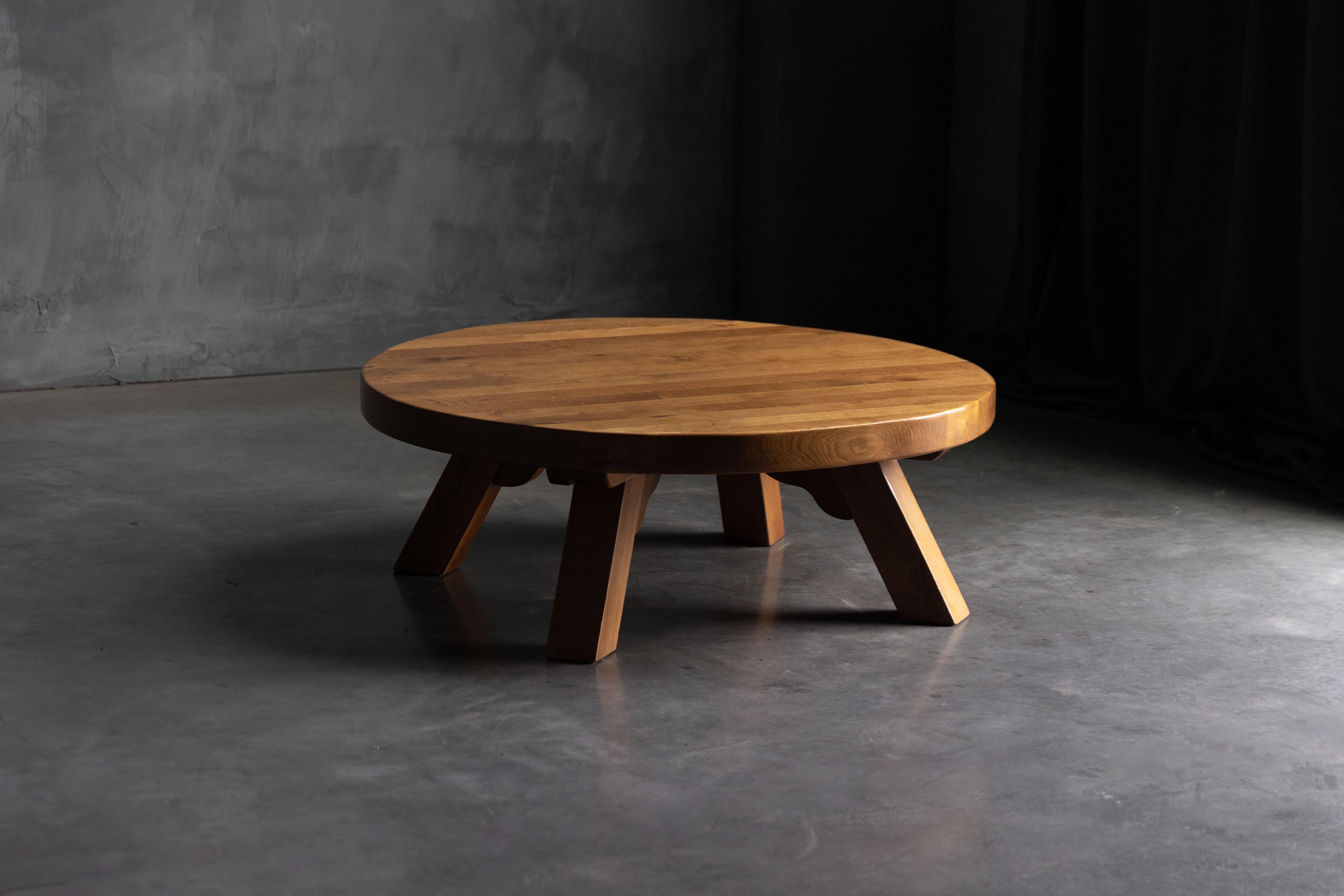 Originaria de Francia en la década de 1970, esta mesa de centro redonda brutalista está fabricada en roble macizo, con unas proporciones atrevidas y un rico veteado natural. La gruesa encimera circular descansa sobre robustas patas angulares con