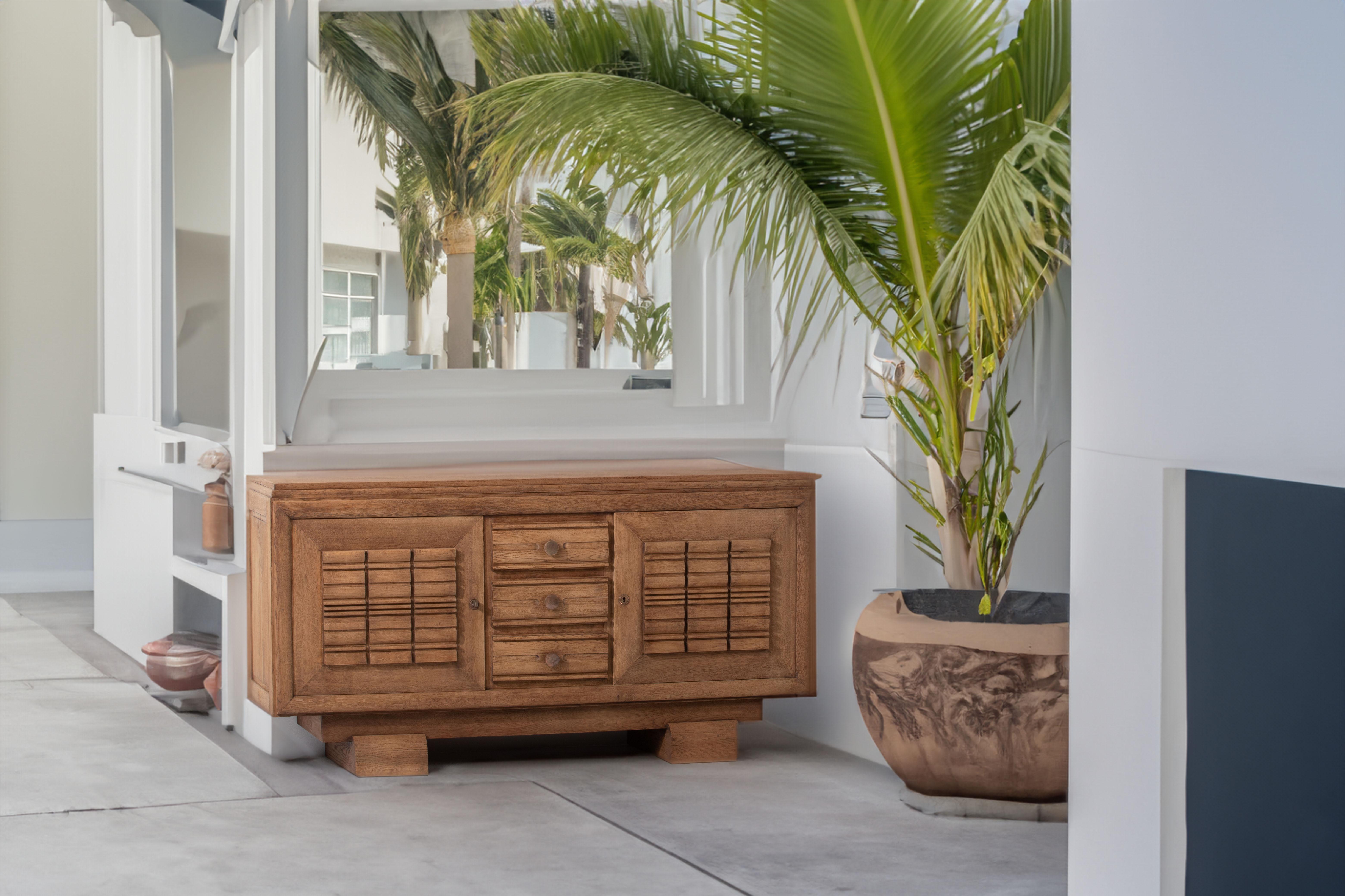 Introducing a magnificent French oak sideboard, inspired by the bold and distinctive style of renowned designer Charles Dudouyt. This brutalist piece exudes a strong and commanding presence, with its symmetrical design and exceptional