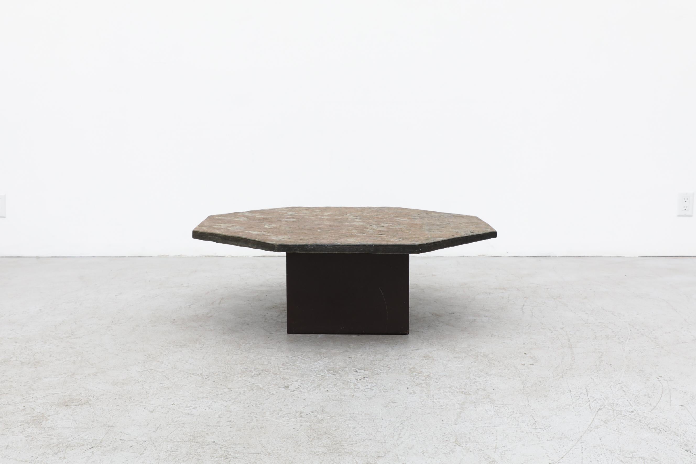 Brutalist, handsome, octagonal stone topped side or coffee table with an enameled metal pedestal base. In original condition with visible patina and wear consistent with its age and use.