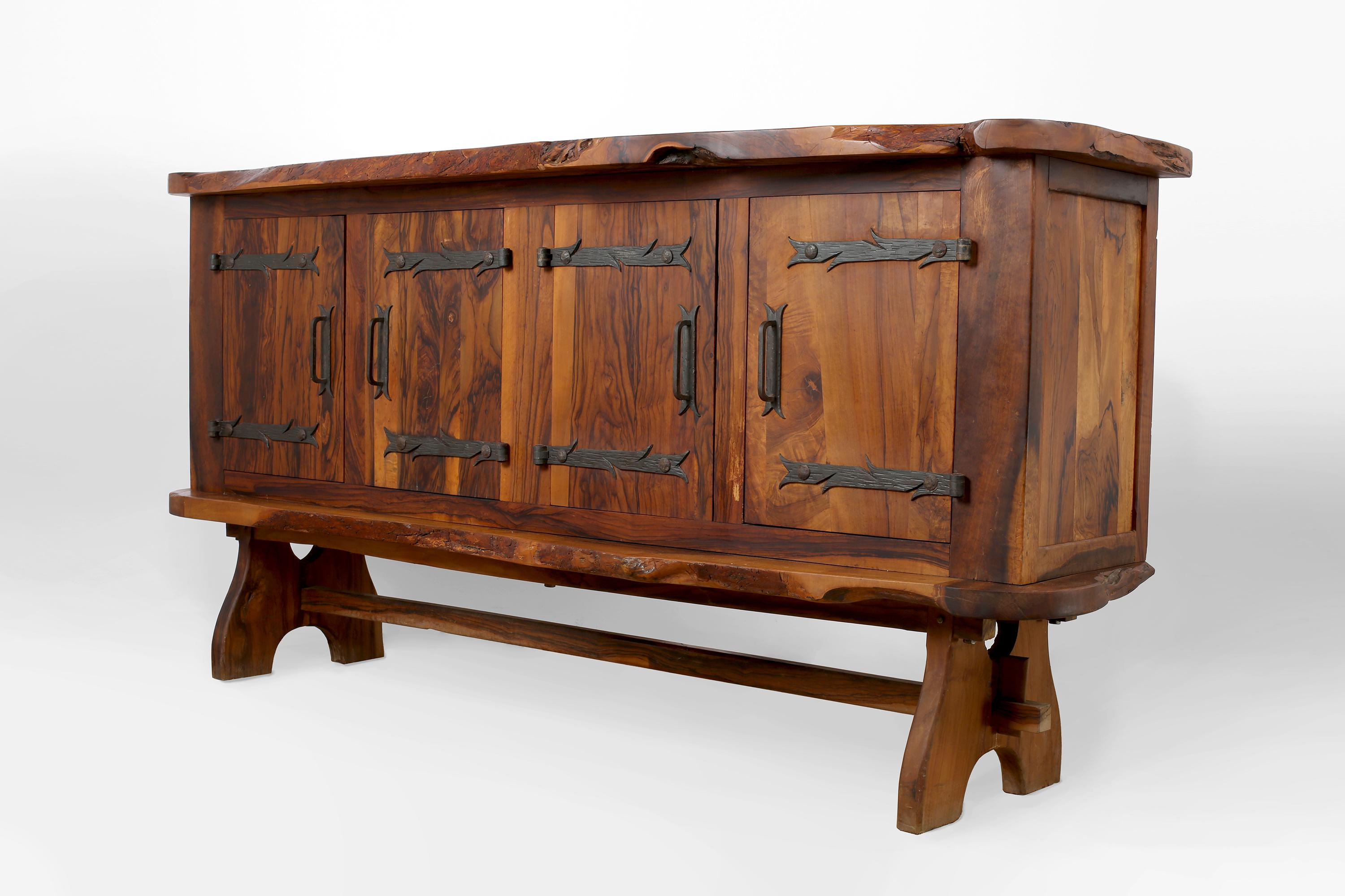 A brutalist solid olive wood four-door sideboard with free form edges and decorative iron hardware. In the style of Alexandre Noll. French, c. 1960s.