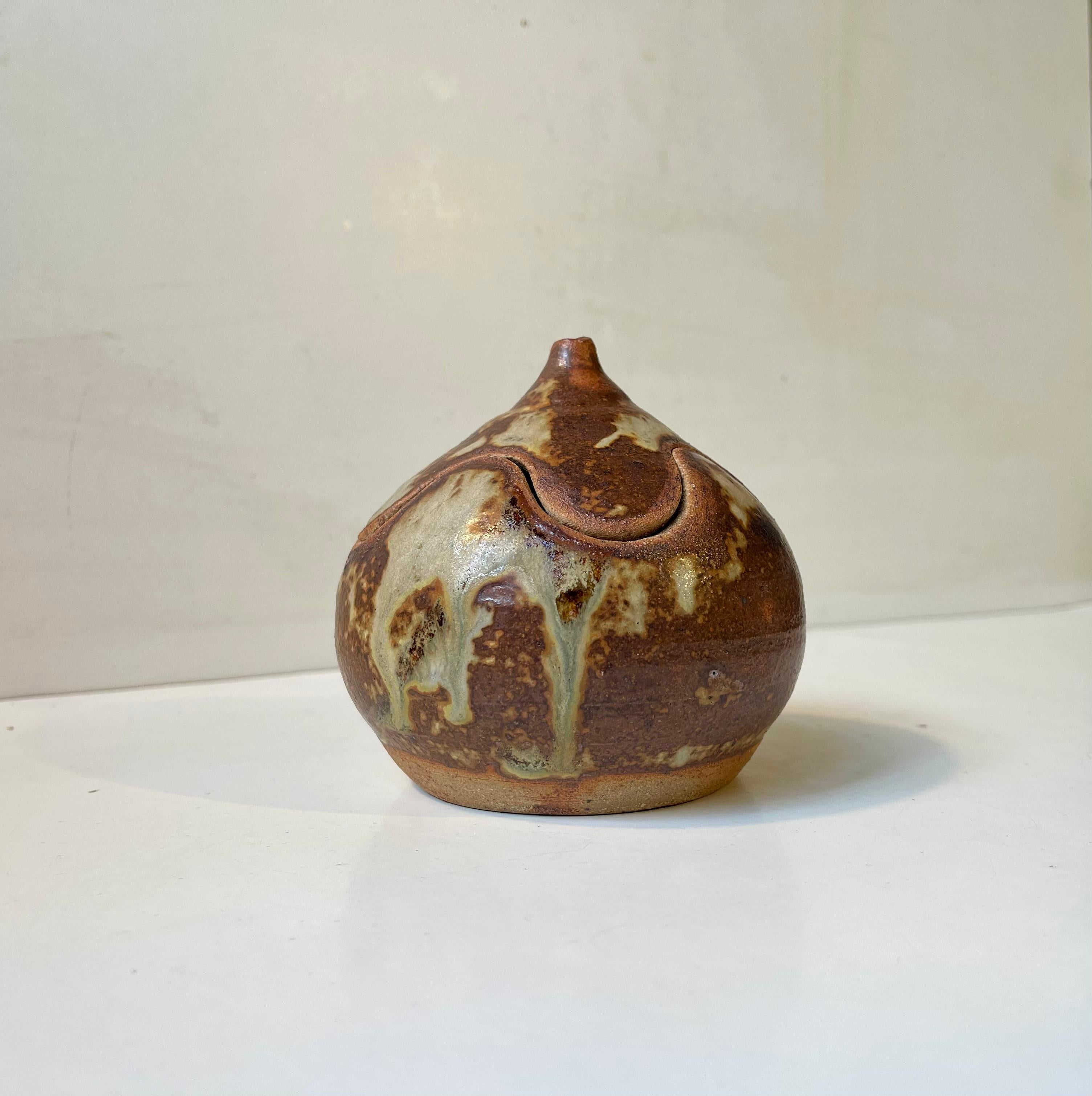 Onion shaped stoneware jar executed in earthy over-flow glazes. Made by Søren and Pirella Visby in Denmark during the 1970s. Signed Visby - Denmark to its base. 

Measurements: H: 10 cm, D: 10 cm.