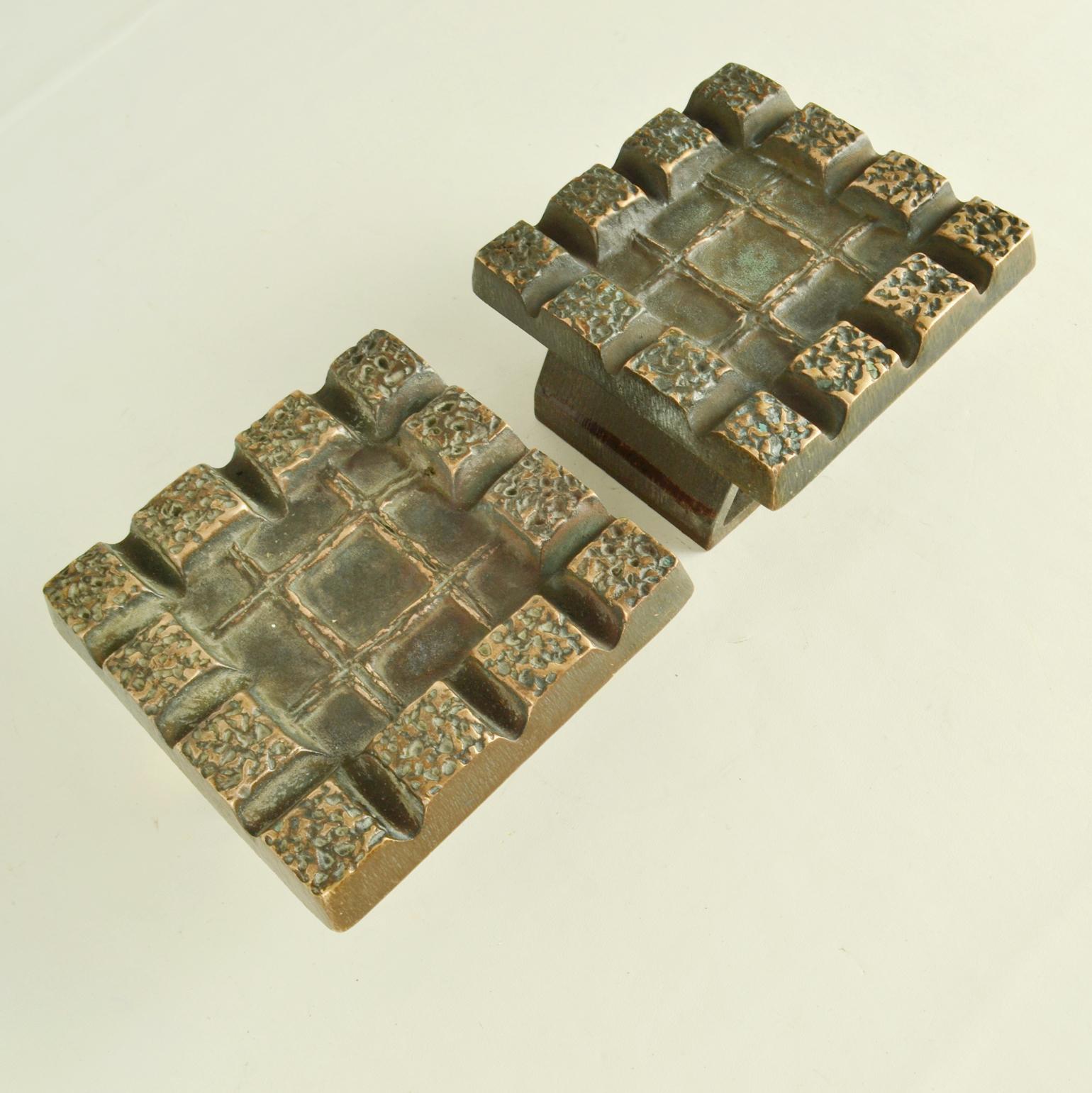 Coppia brutalista di rilievi in bronzo con un forte rilievo e un motivo geometrico con ripetizione di quadrati, realizzata negli anni 1960-70. Questi pesanti pezzi, realizzati in bronzo fuso, sono in perfette condizioni. Il bronzo è oidizzato,