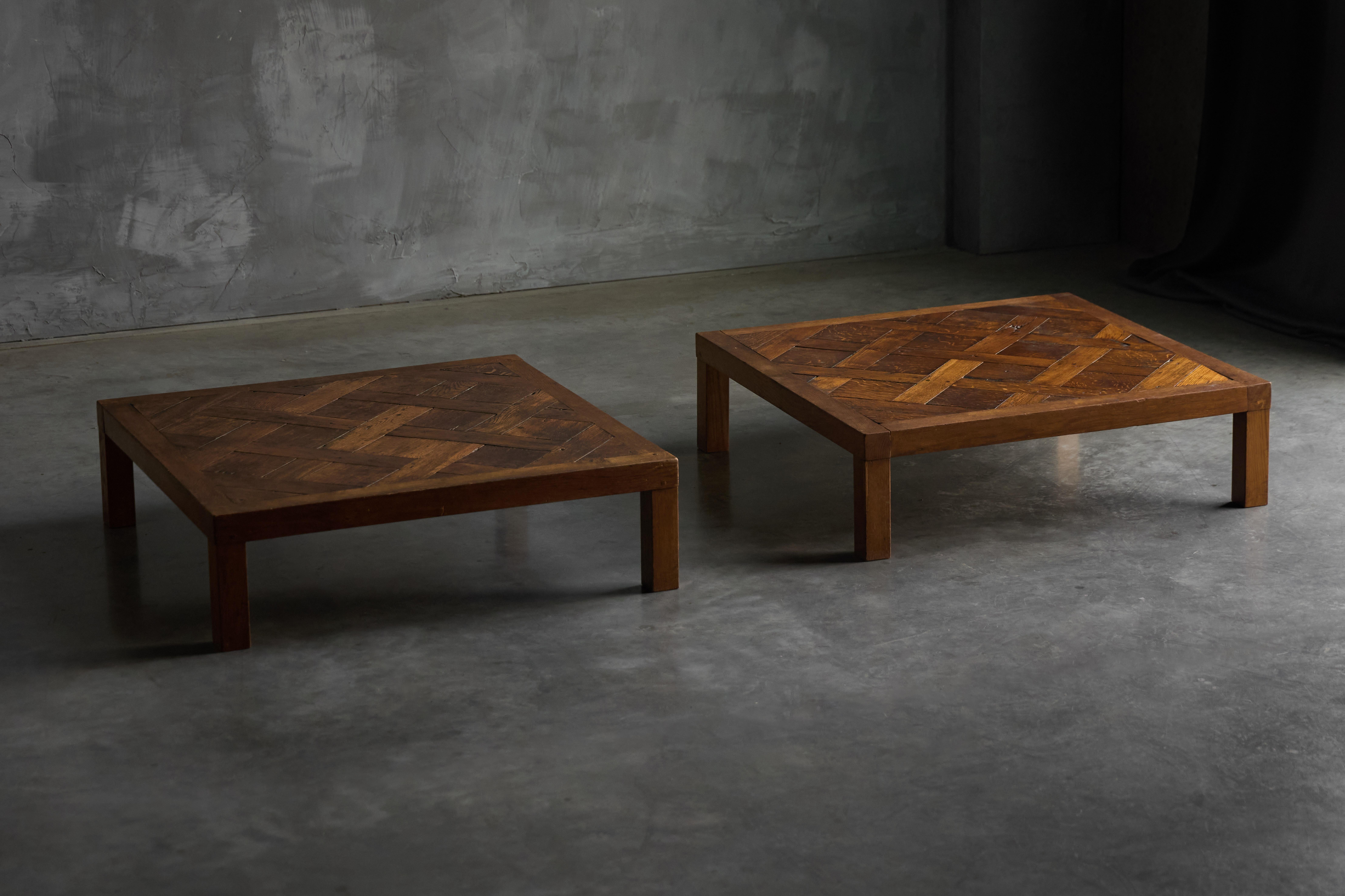 A striking low coffee table crafted in solid oak, featuring an intricate parquet top with a rich, warm patina that highlights the natural grain and age of the wood. Its geometric pattern and solid square legs lend both texture and balance. Ideal for