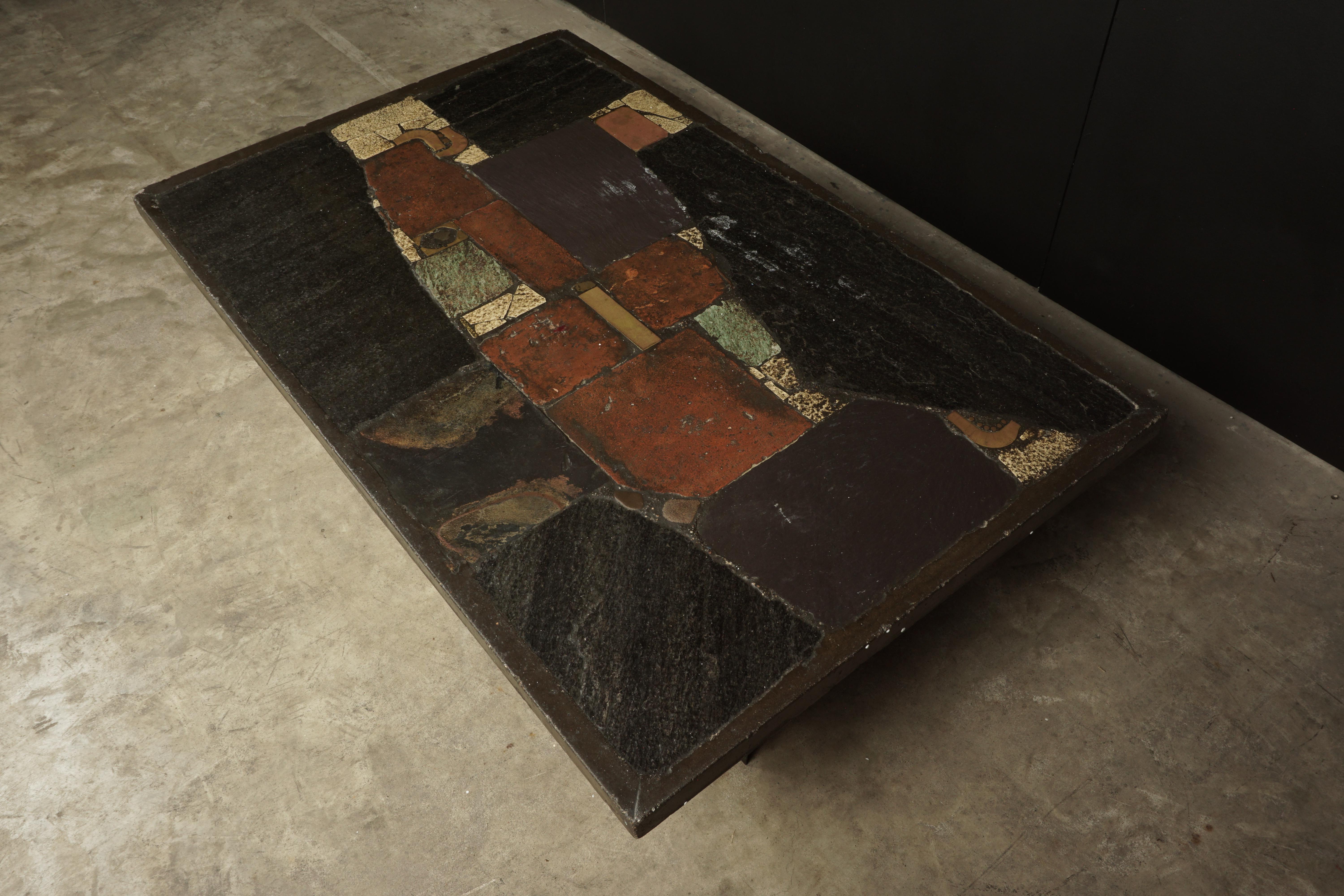 Brutalist Paul Kingma coffee table from Holland, 1960s. Concrete top inlaid with mosaic slate and stone. Black metal lacquered feet. Singed Kingma on the top.