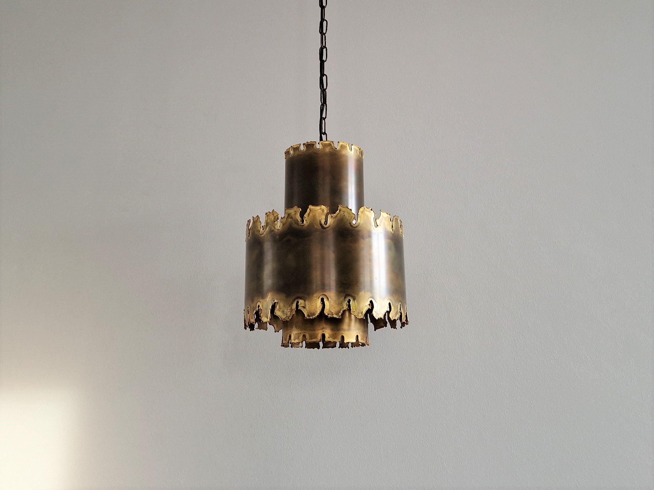 Cette superbe lampe suspendue brutaliste, modèle 6407, a été conçue par Svend Aage Holm Sørensen pour Sørensen & Co au Danemark dans les années 1960. L'utilisation et le travail du laiton oxydé font de ce luminaire un objet impressionnant. La lampe