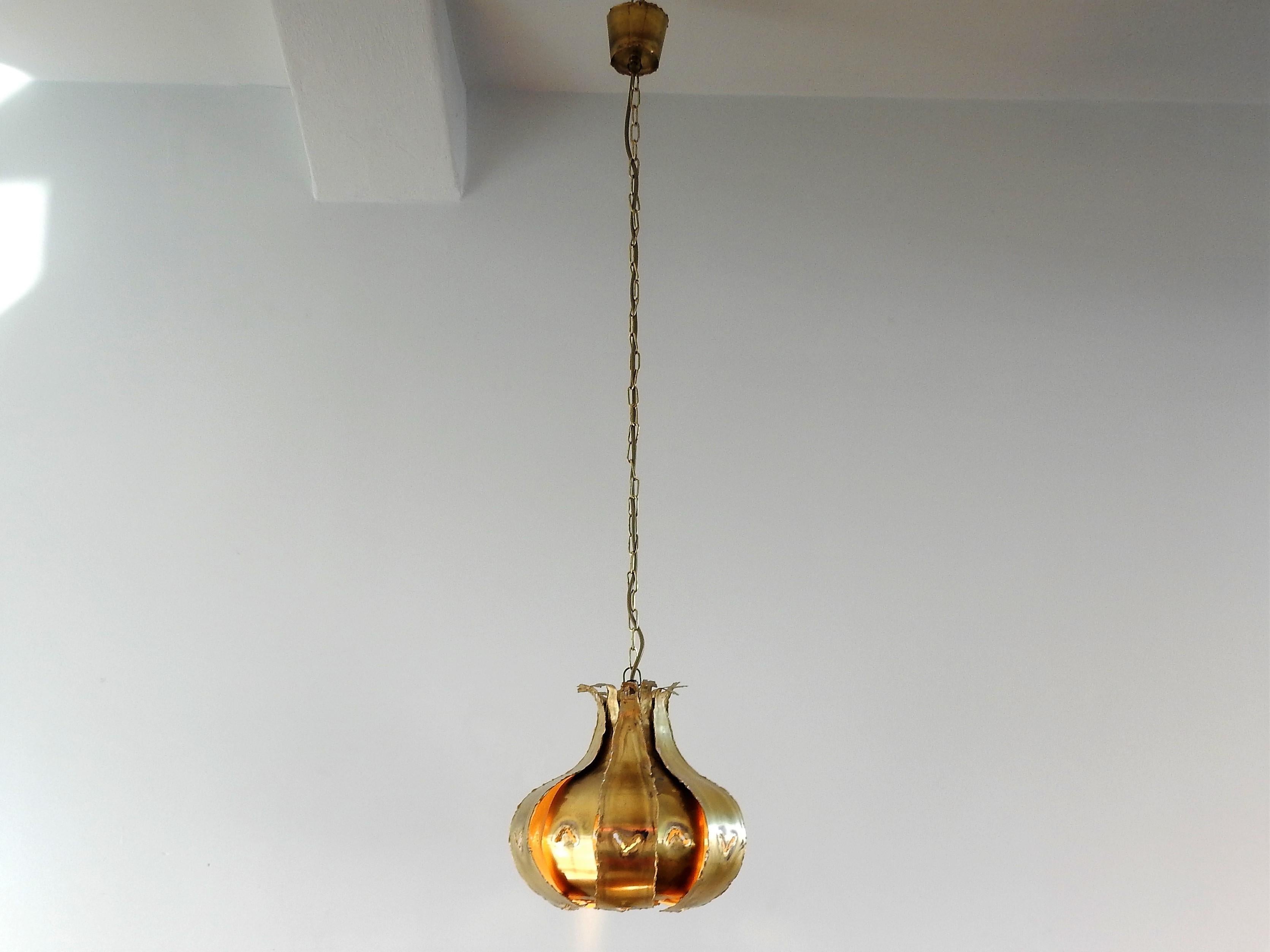 This Brutalist pendant lamp is a production by Thea Metal from Denmark. The design is by Svend Aage Holm Sorensen or inspired on designs by him. The 'onion' shaped lamp consists out of burned brass 'leaves' that was a charcteristic proces of Svend