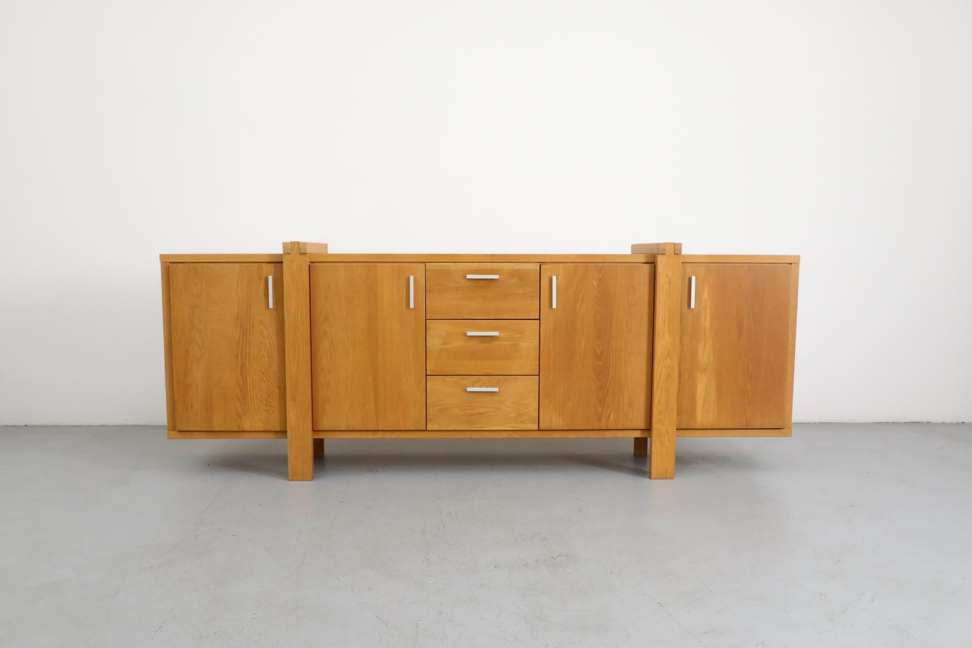 Mintjens Belgische Meubelmakers Buffet brutaliste en chêne avec 4 portes et 3 tiroirs, tous avec de fines poignées en aluminium,. Une belle construction avec des pieds qui s'enroulent autour de la pièce. En état d'origine avec une usure visible, y