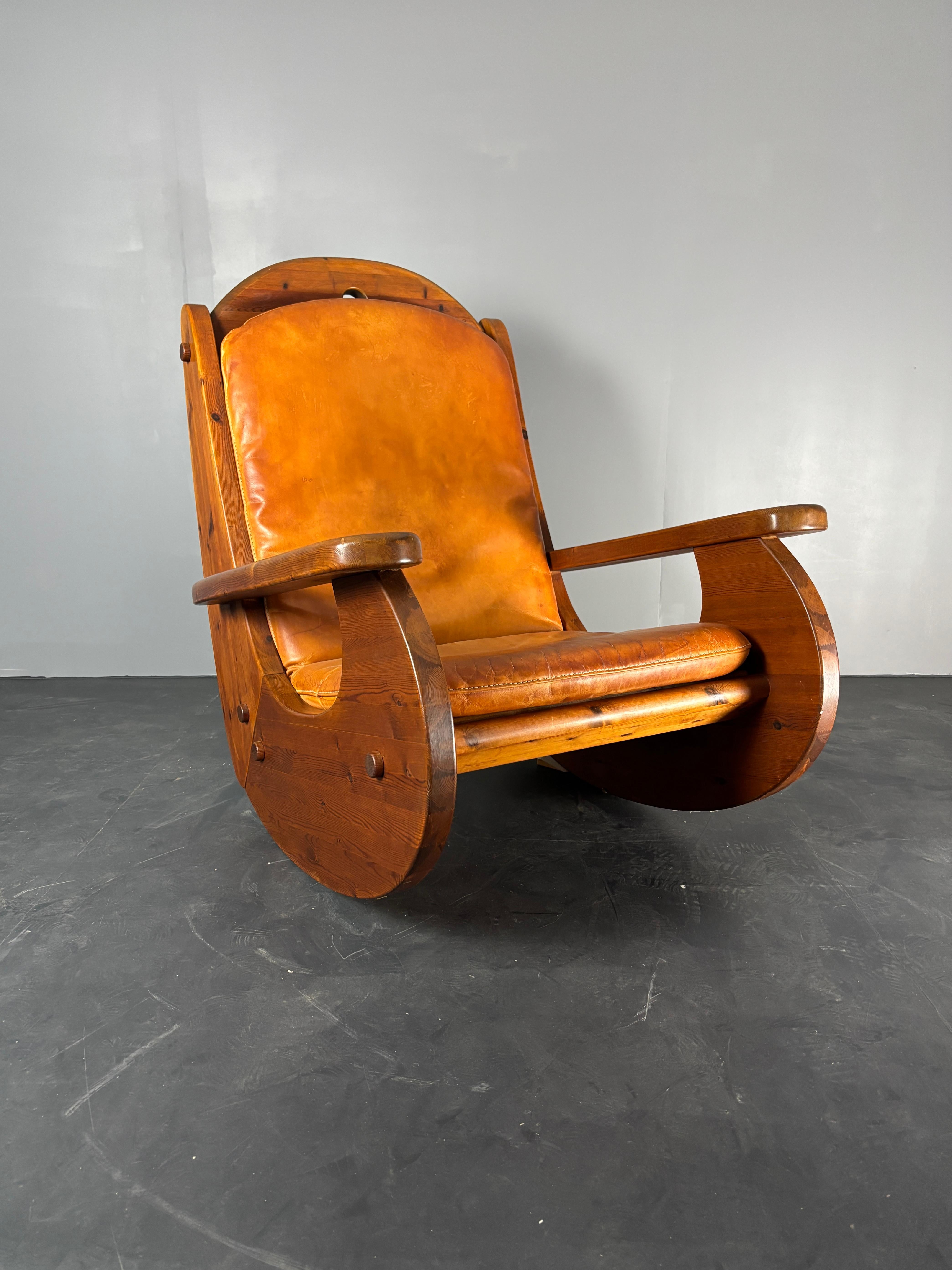 Chaise à bascule en pin conçue à l'origine dans les années 1970 selon certains mais celle-ci est Cleary marquée 1984 par Wasa ( Allemagne ). La chaise est en excellent état avec seulement une usure minime sur le bas du pin et le cuir cognac est dans