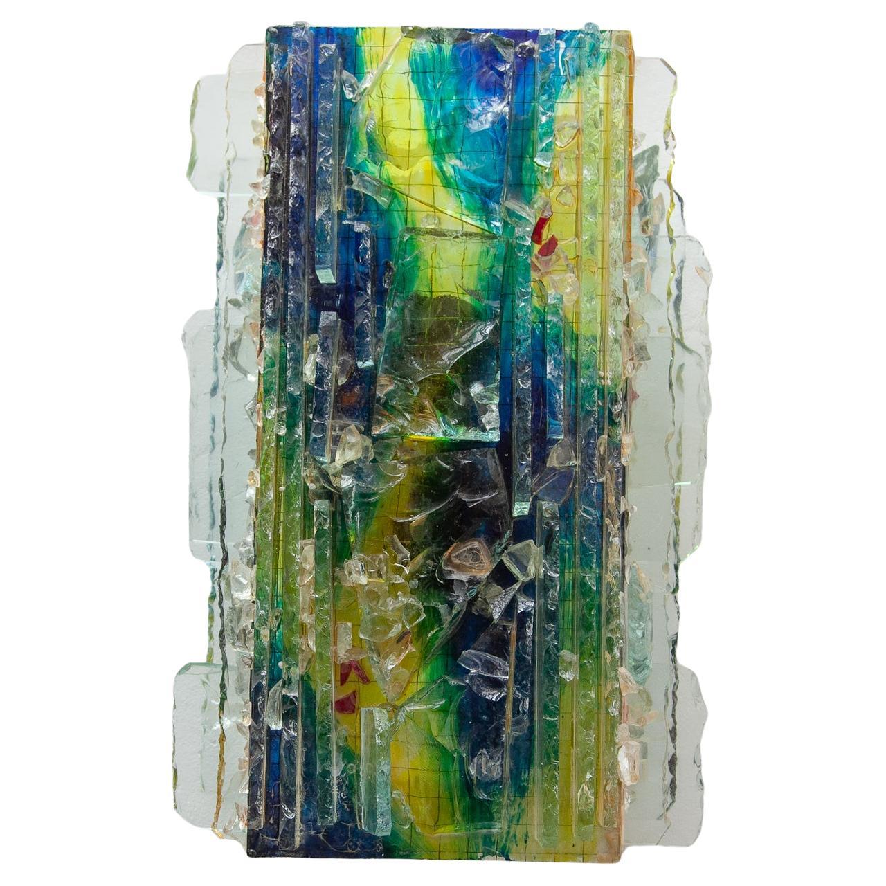 Aplique de pared de mediados de siglo hecho a mano por Willen van Oyen para la manufactura Raak, Países Bajos. El aplique brutalista tiene una hermosa luz con colores ascendentes en verde y azul en contraste con las partes de cristal transparente.