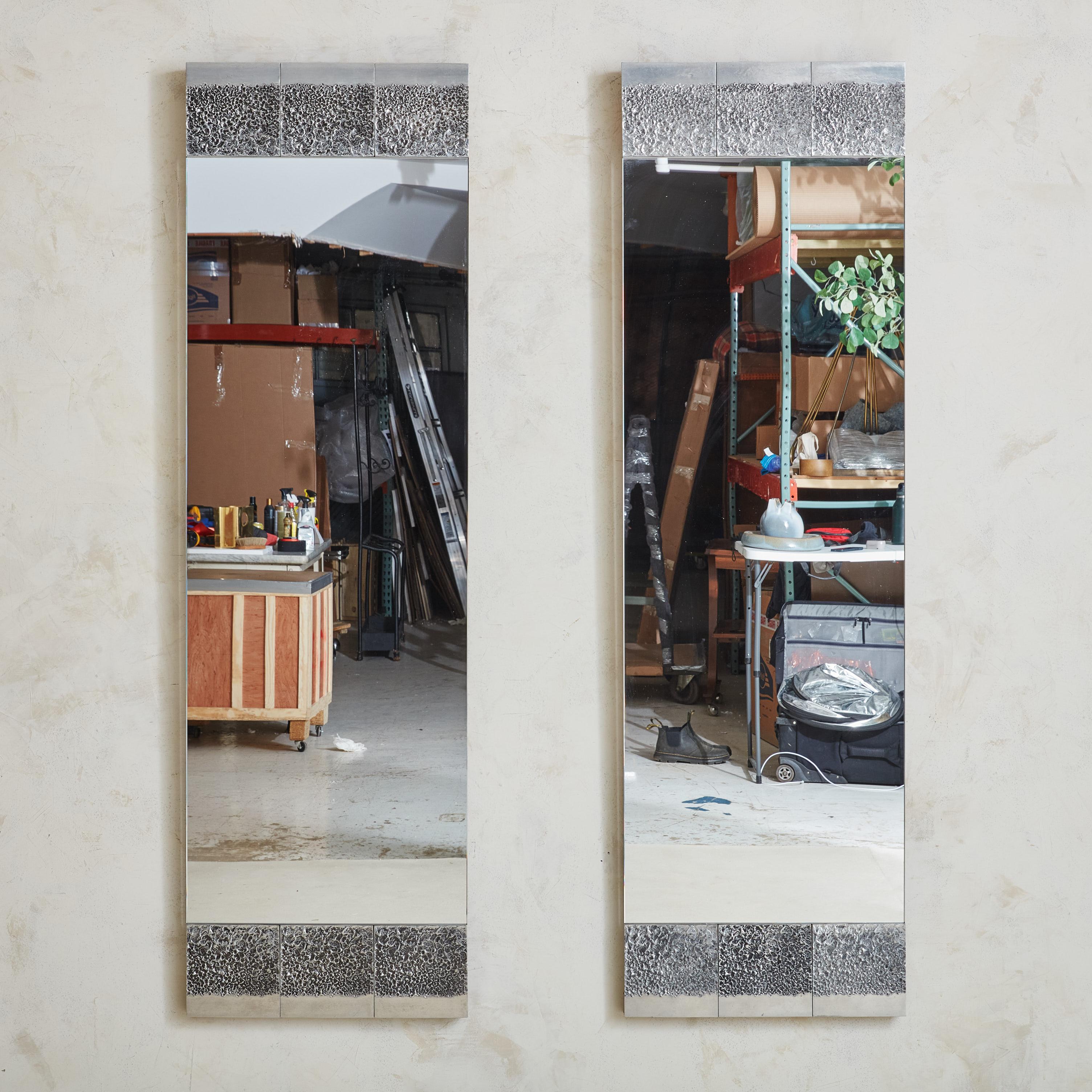 Vendus et tarifés individuellement.

Miroir fabriqué à la main par l'artiste Bianca Garinei. Ce grand miroir sculptural présente un panneau en métal patiné avec une texture martelée sur le dessus et la base. Un support en bois soutient le miroir, et