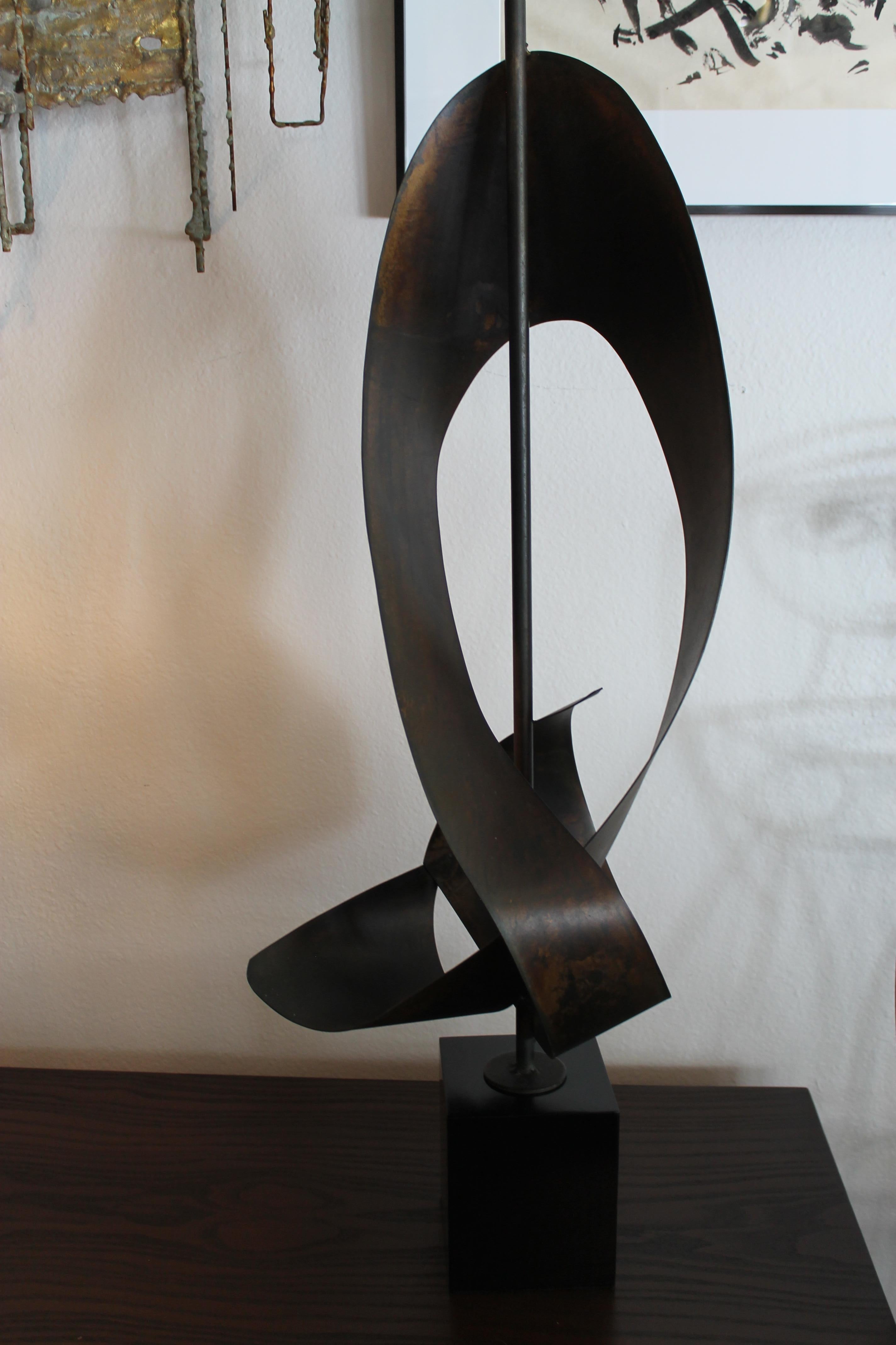 Ribbon cut Brutalist lamp by Harold Weiss (founder) and Richard Barr who were the Laurel designers at the time for the Laurel Lamp Company. Abstracted ribbon shape on black enamel painted square base. Lamp has been professionally rewired for 3-way