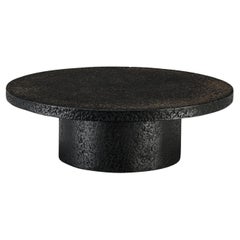 Table basse ronde brutaliste en résine noire aspect pierre 